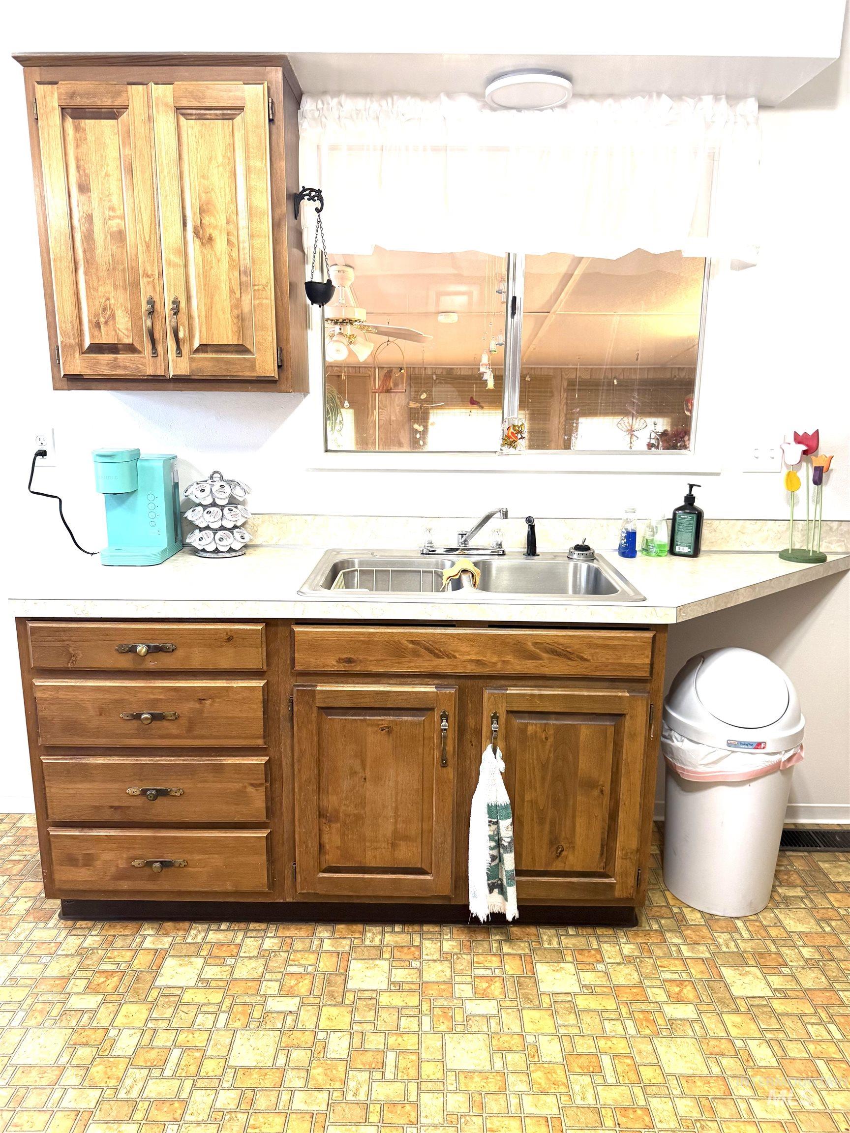 Bar area with light countertops, brown cabinetry, and brick patterned floors