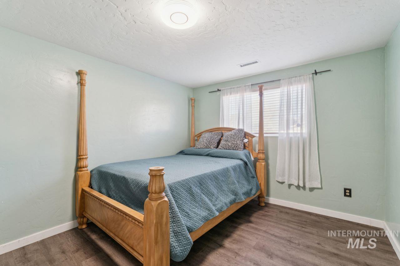 Bedroom with dark wood-type flooring and a textured ceiling