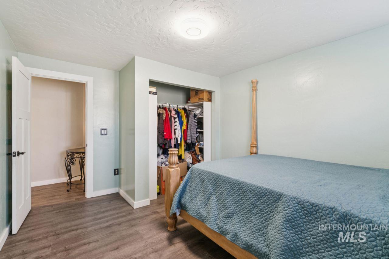 Bedroom featuring wood finished floors, a closet, and a textured ceiling