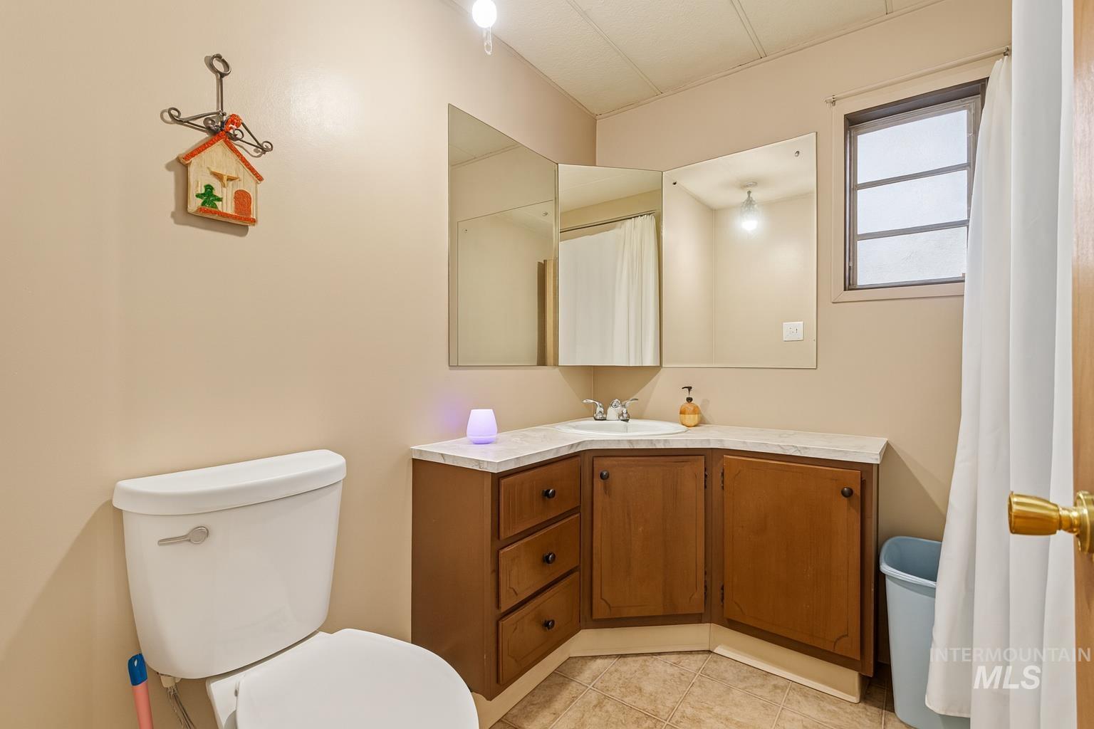 Bathroom featuring vanity, light tile patterned flooring, and a shower with shower curtain