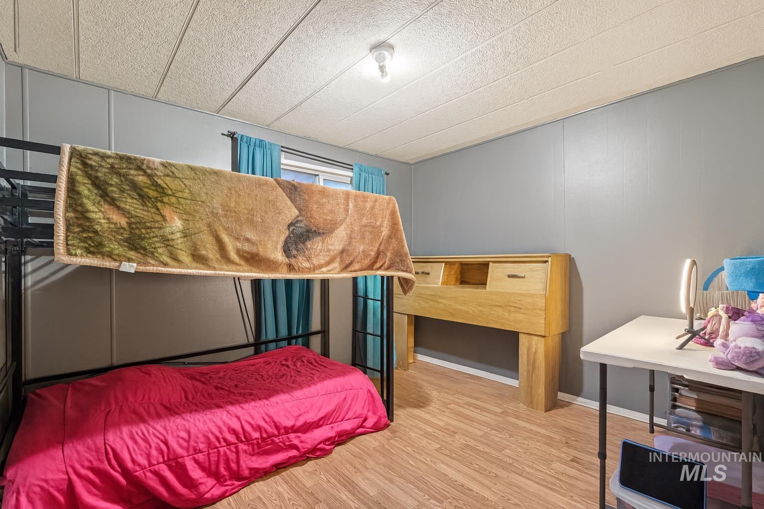 Bedroom featuring wood finished floors and a textured ceiling