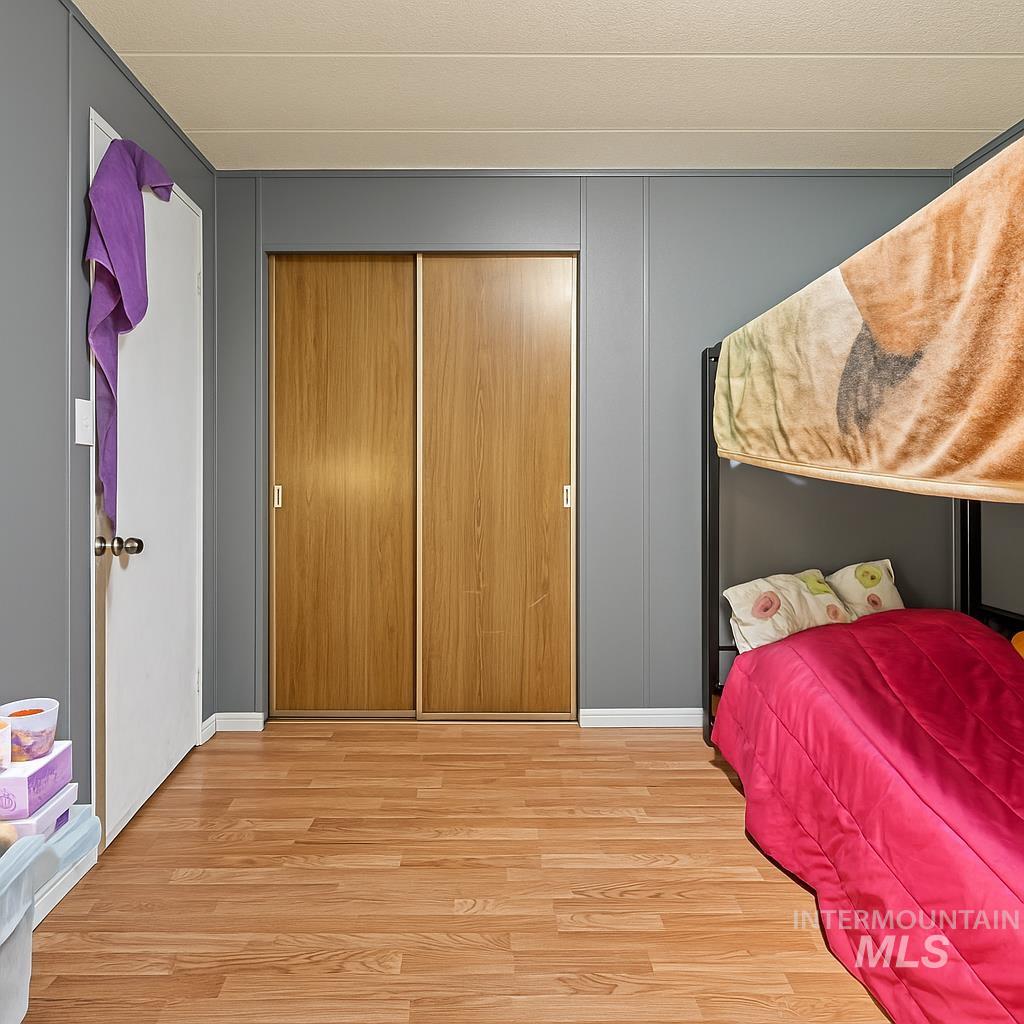 Bedroom featuring wood finished floors and a closet