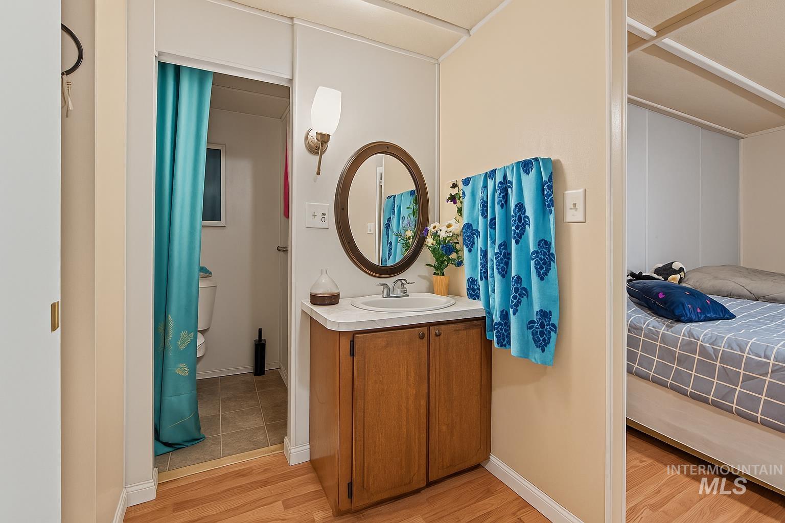 Ensuite bathroom featuring vanity and light wood-type flooring
