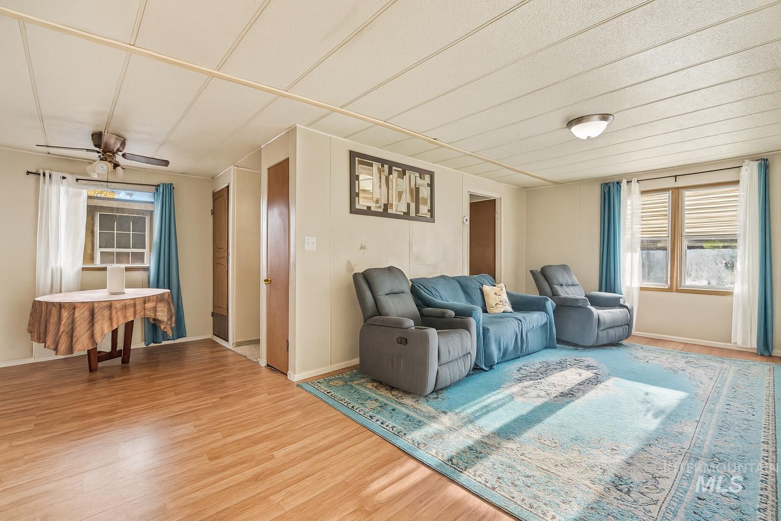 Living area with wood finished floors and ceiling fan