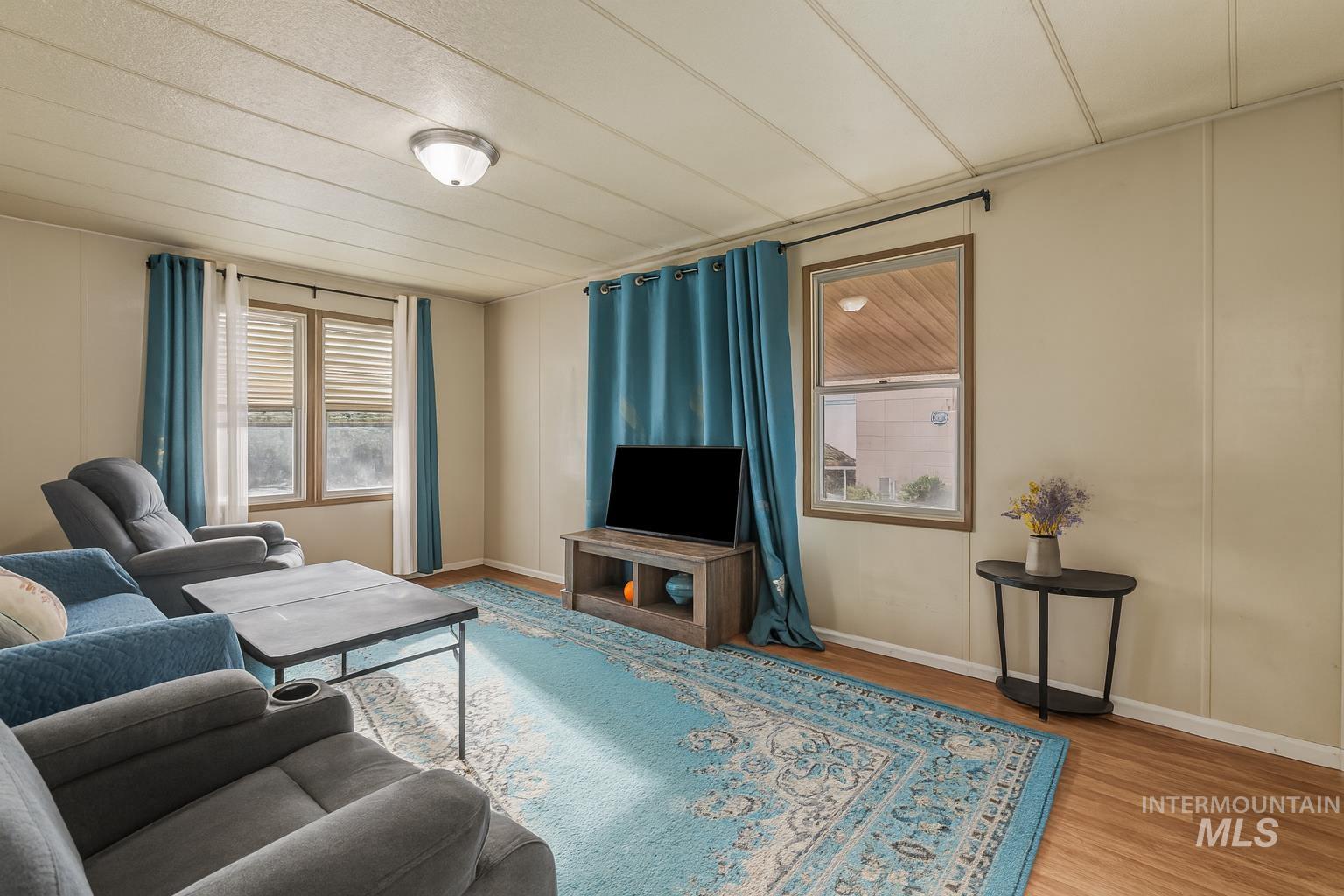 Living room featuring wood finished floors, plenty of natural light, and a decorative wall