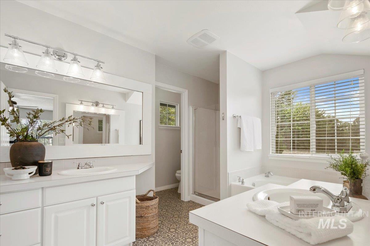 Bathroom featuring a garden tub, vanity, and a stall shower