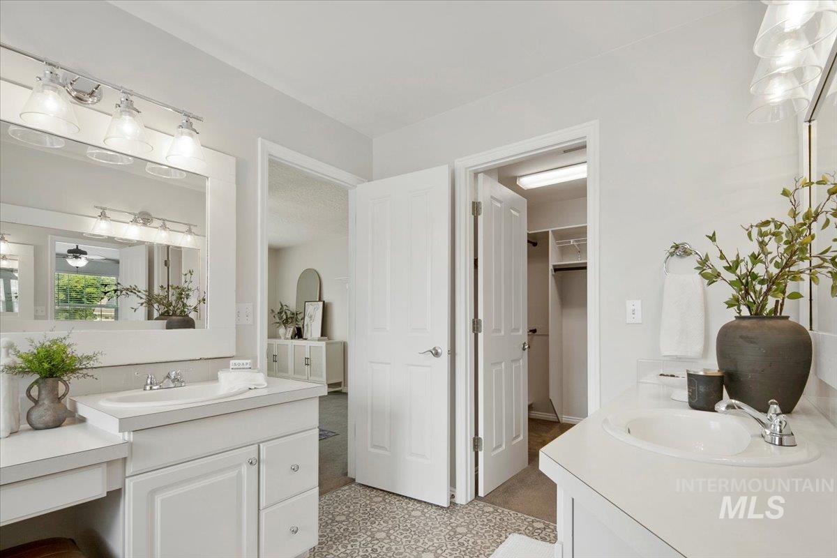 Full bathroom with two vanities and a walk in closet