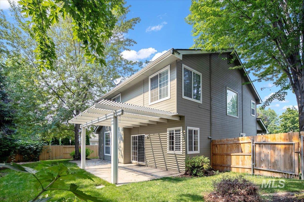 Back of property featuring a pergola, a patio, and a fenced backyard