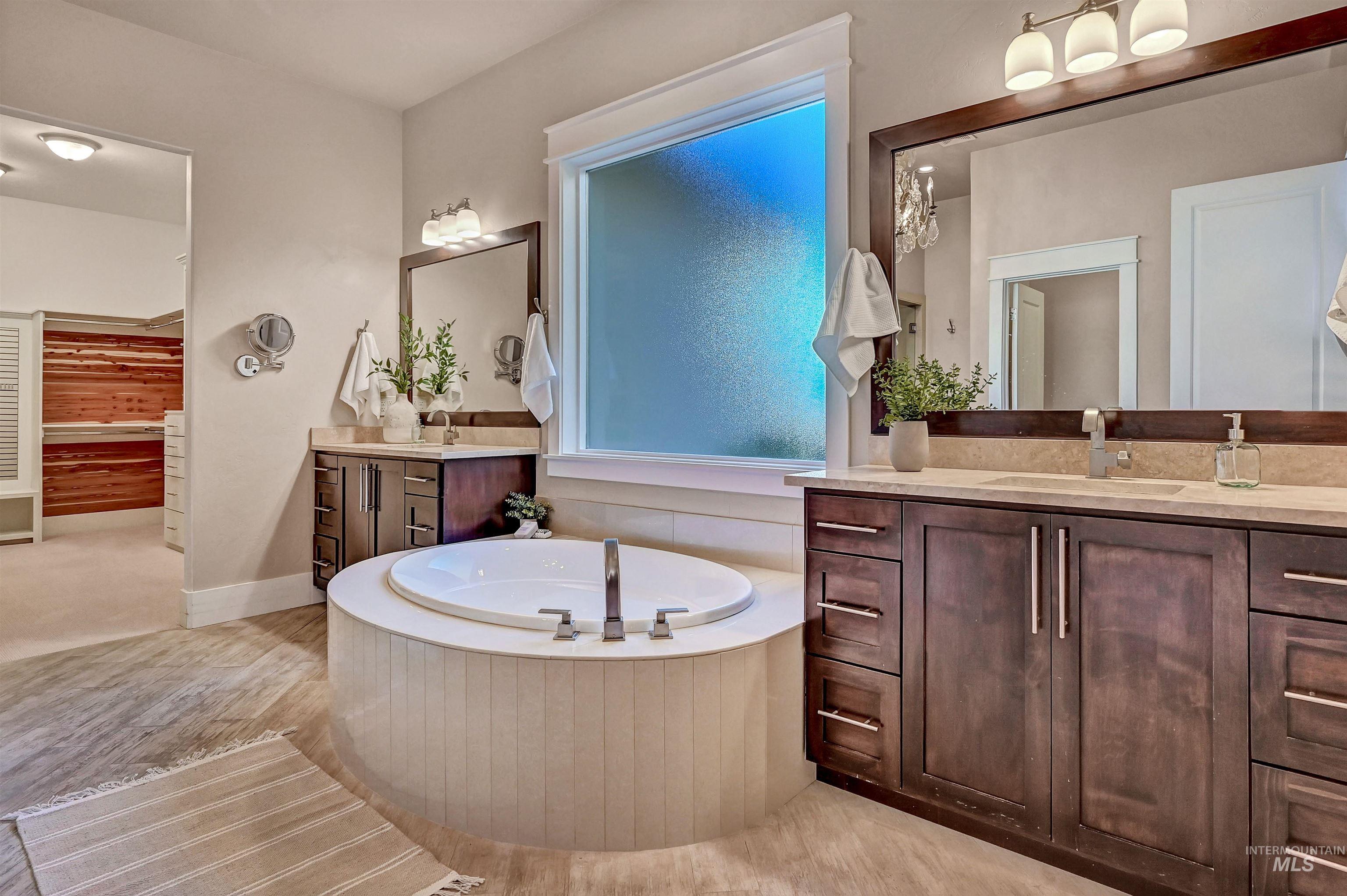 Bathroom featuring a bath and two vanities