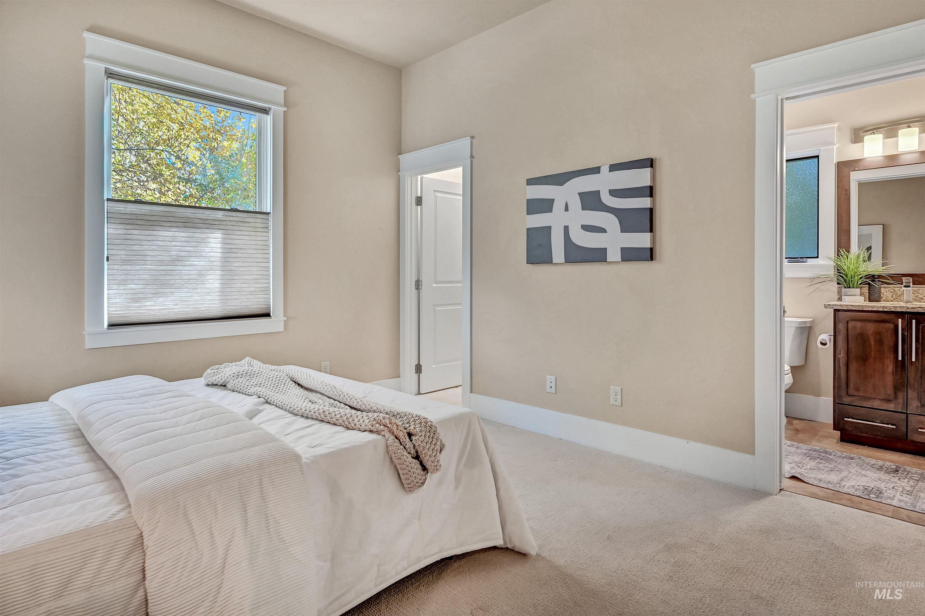 Carpeted bedroom with baseboards and ensuite bathroom