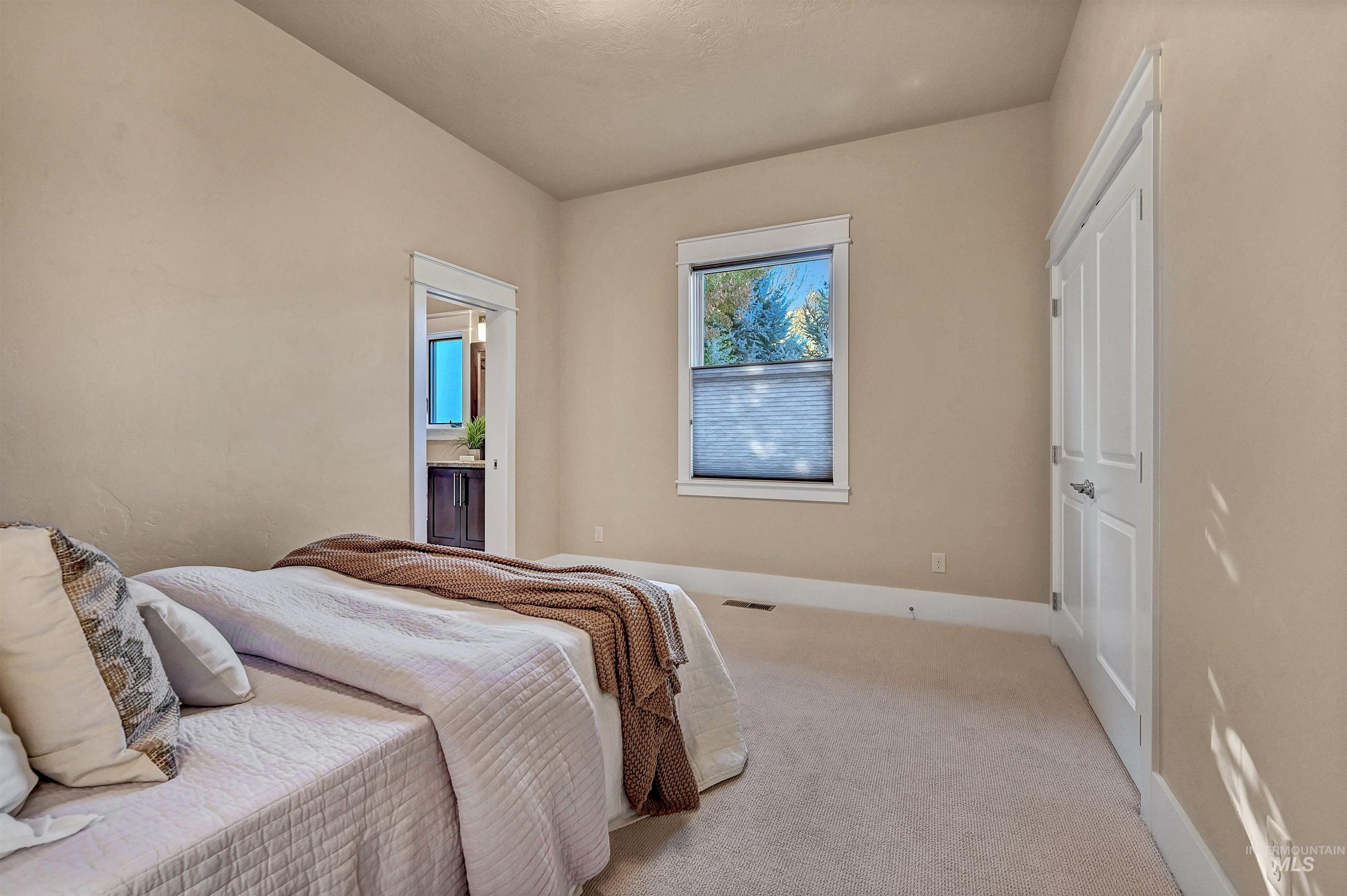 Bedroom with carpet floors and ensuite bath