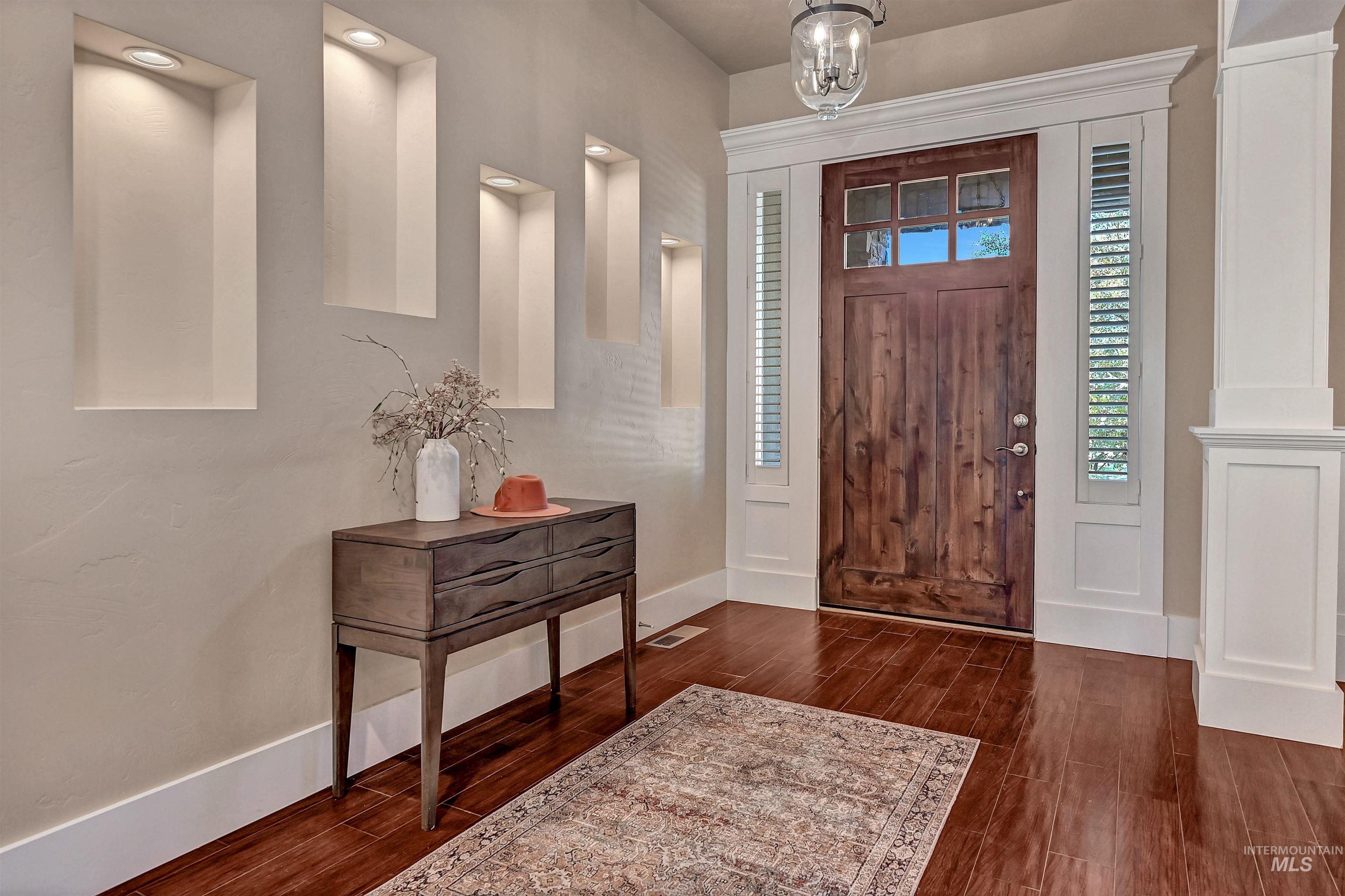 Foyer with dark wood-style flooring and baseboards
