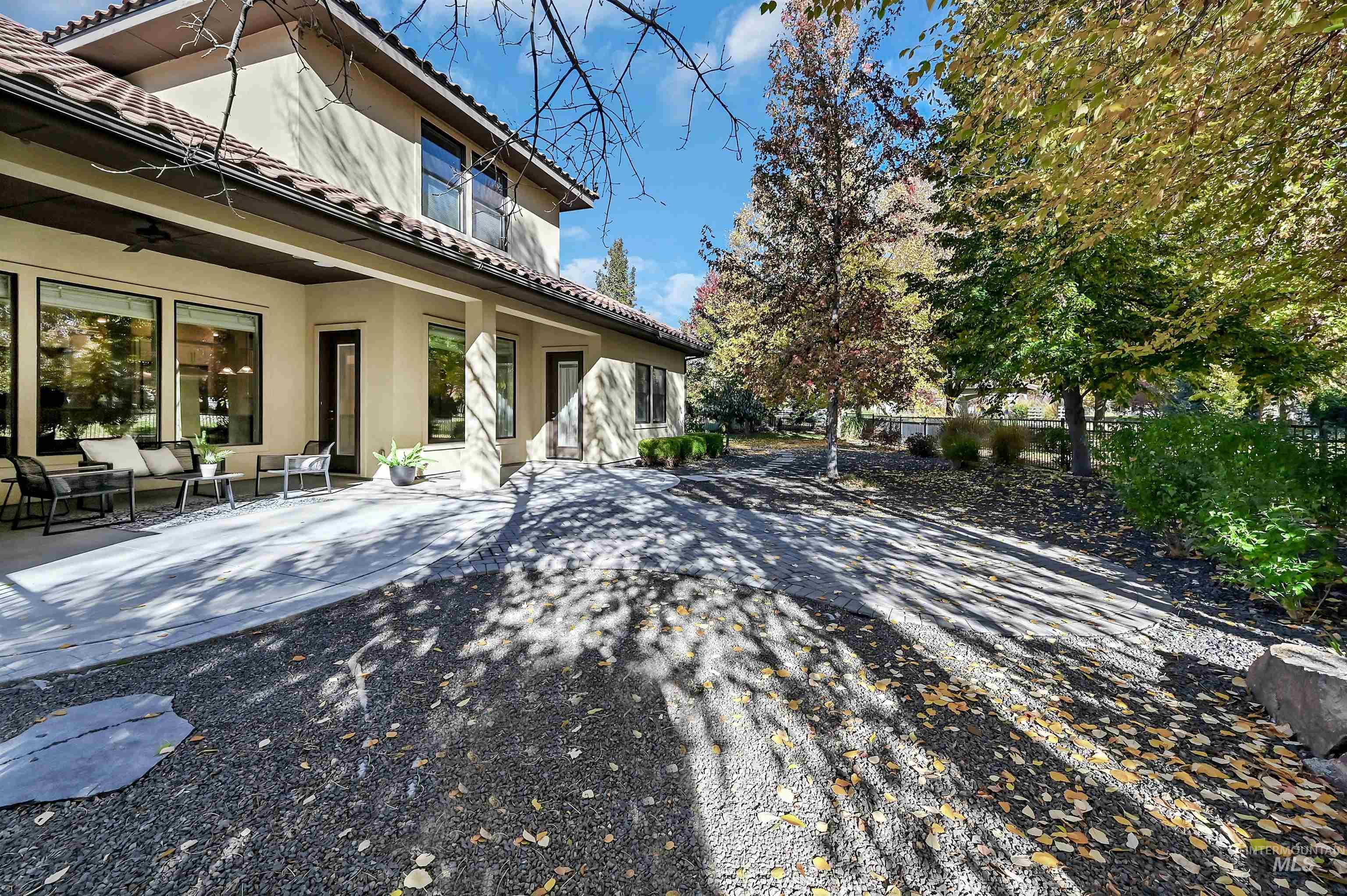 Rear view of property with a tiled roof, ceiling fan, stucco siding, and a patio