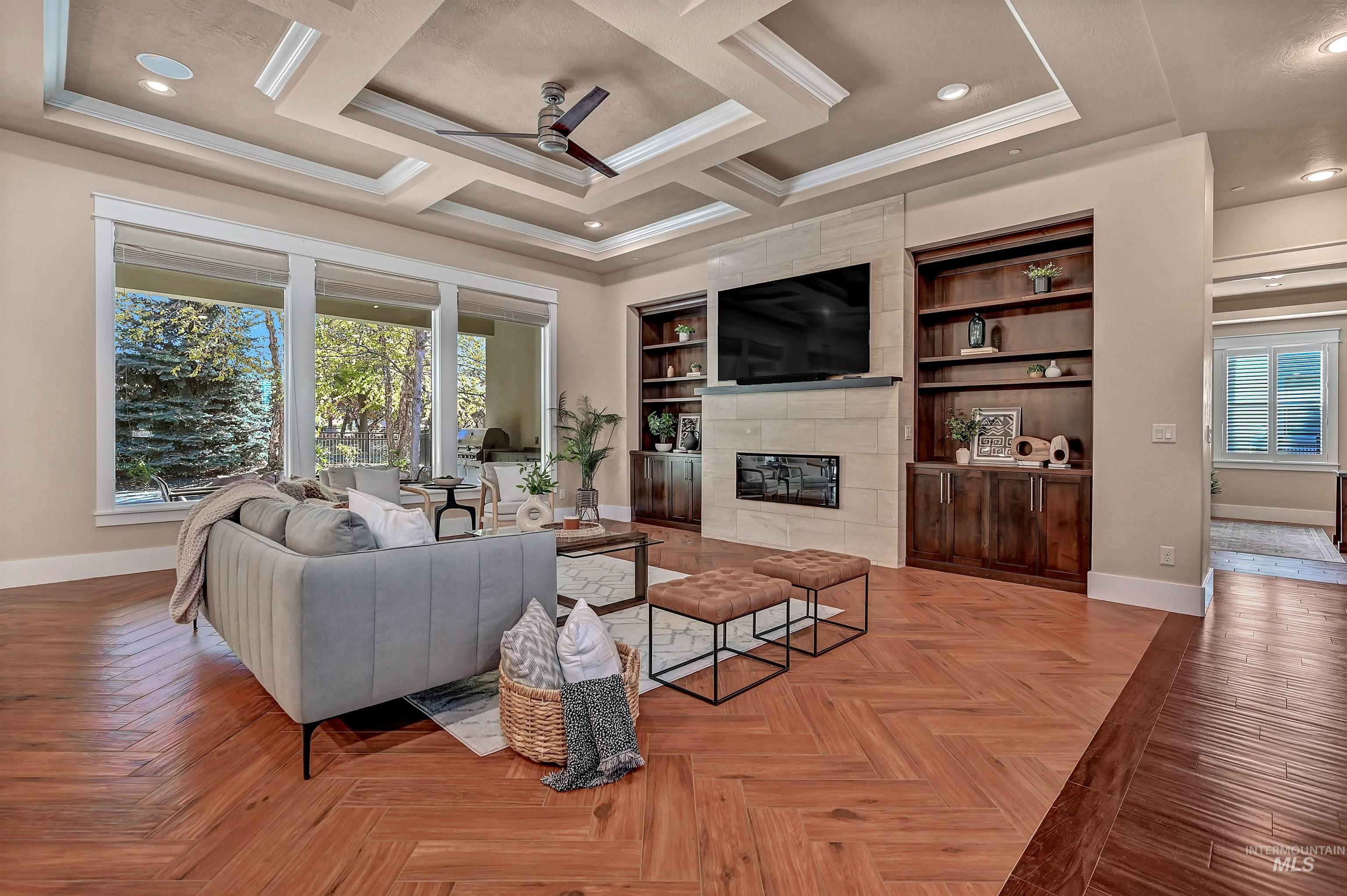 Living area featuring healthy amount of natural light, a tile fireplace, recessed lighting, a ceiling fan, and crown molding