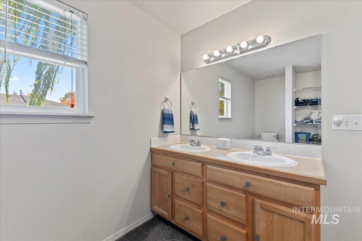 Bathroom with double vanity and a textured wall