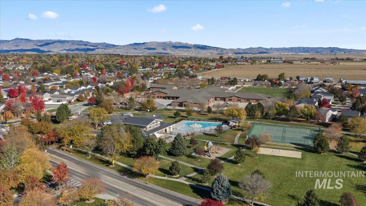 Aerial view of residential area with a mountain backdrop and a pool area