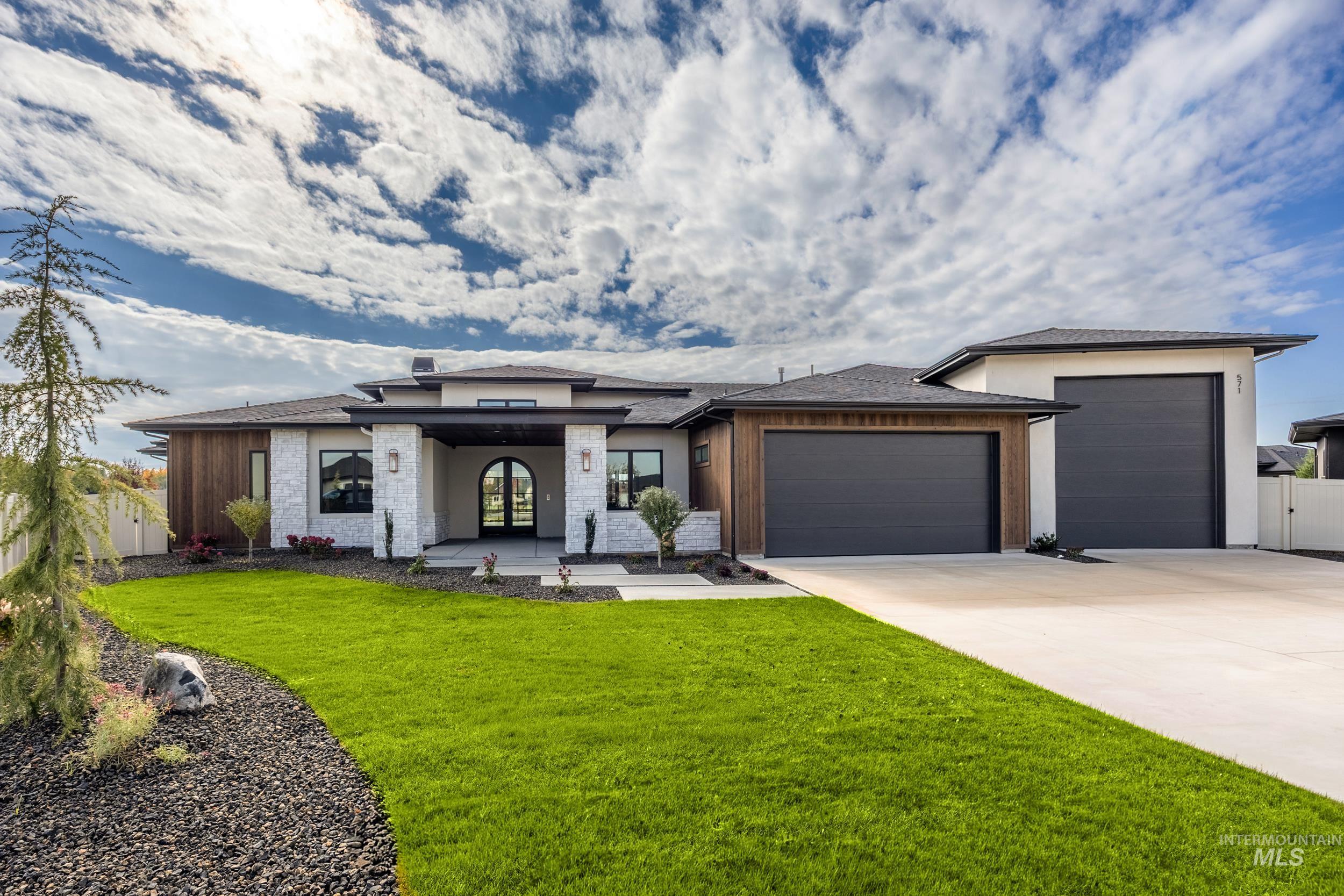 Prairie-style home featuring an attached garage, concrete driveway, a porch, a shingled roof, and french doors