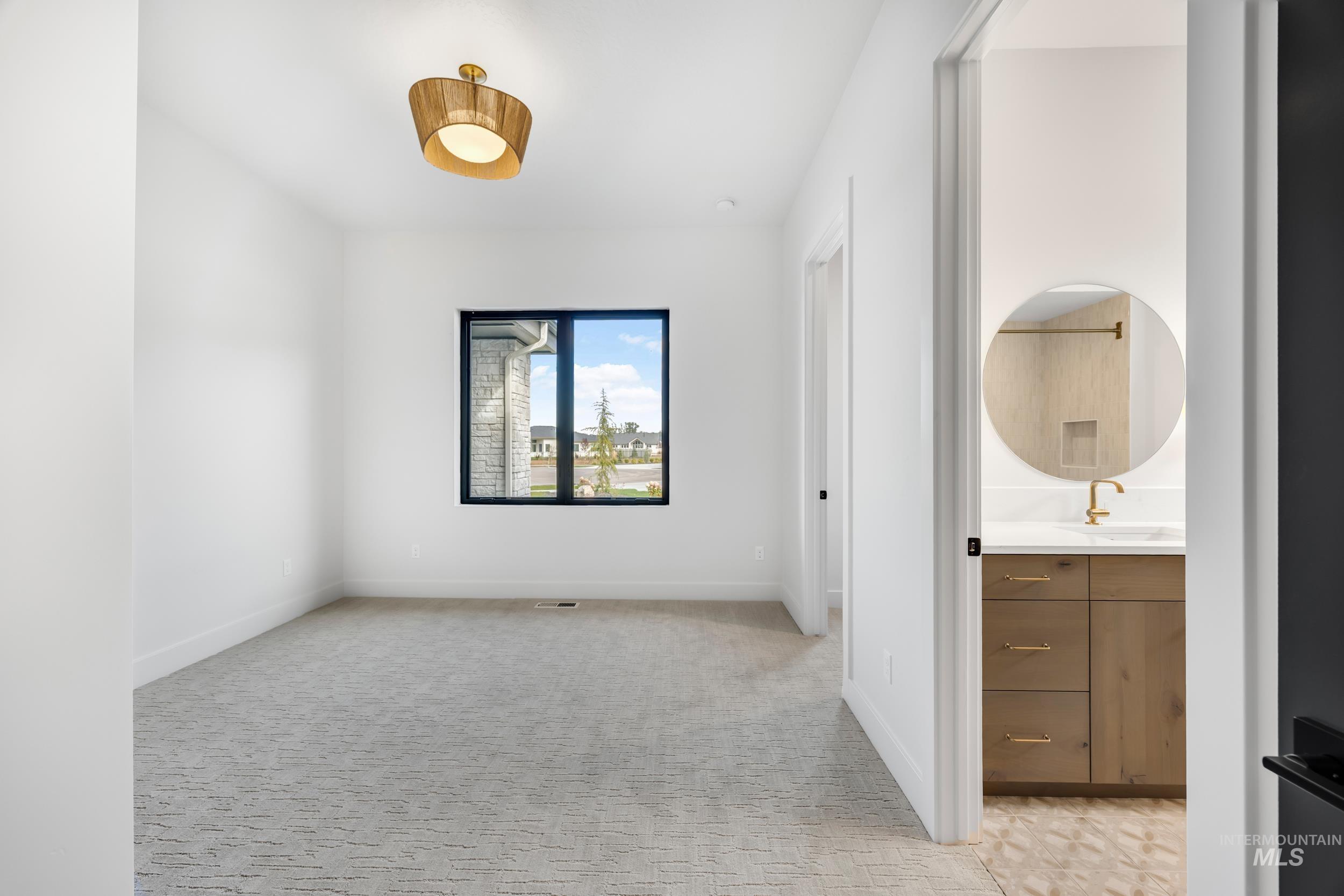 Unfurnished bedroom featuring light colored carpet and ensuite bathroom