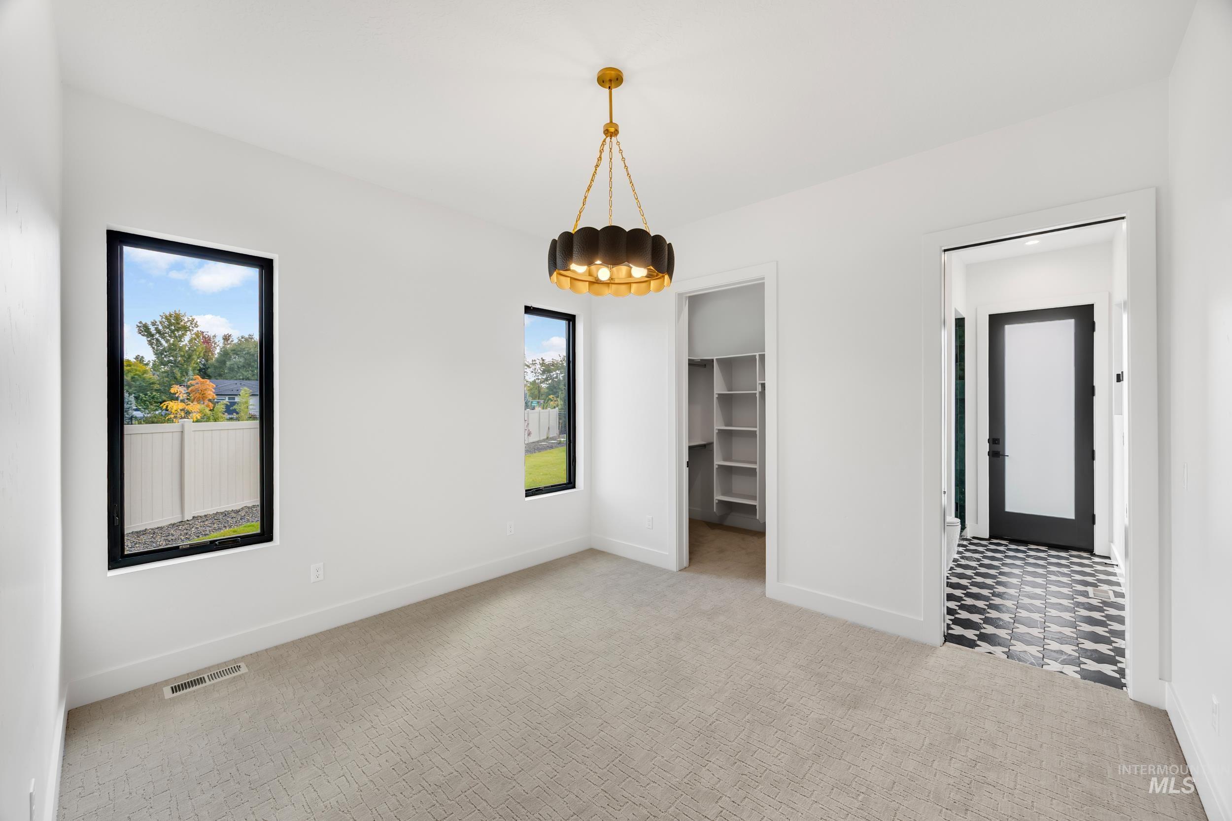 Unfurnished bedroom featuring light colored carpet and a walk in closet