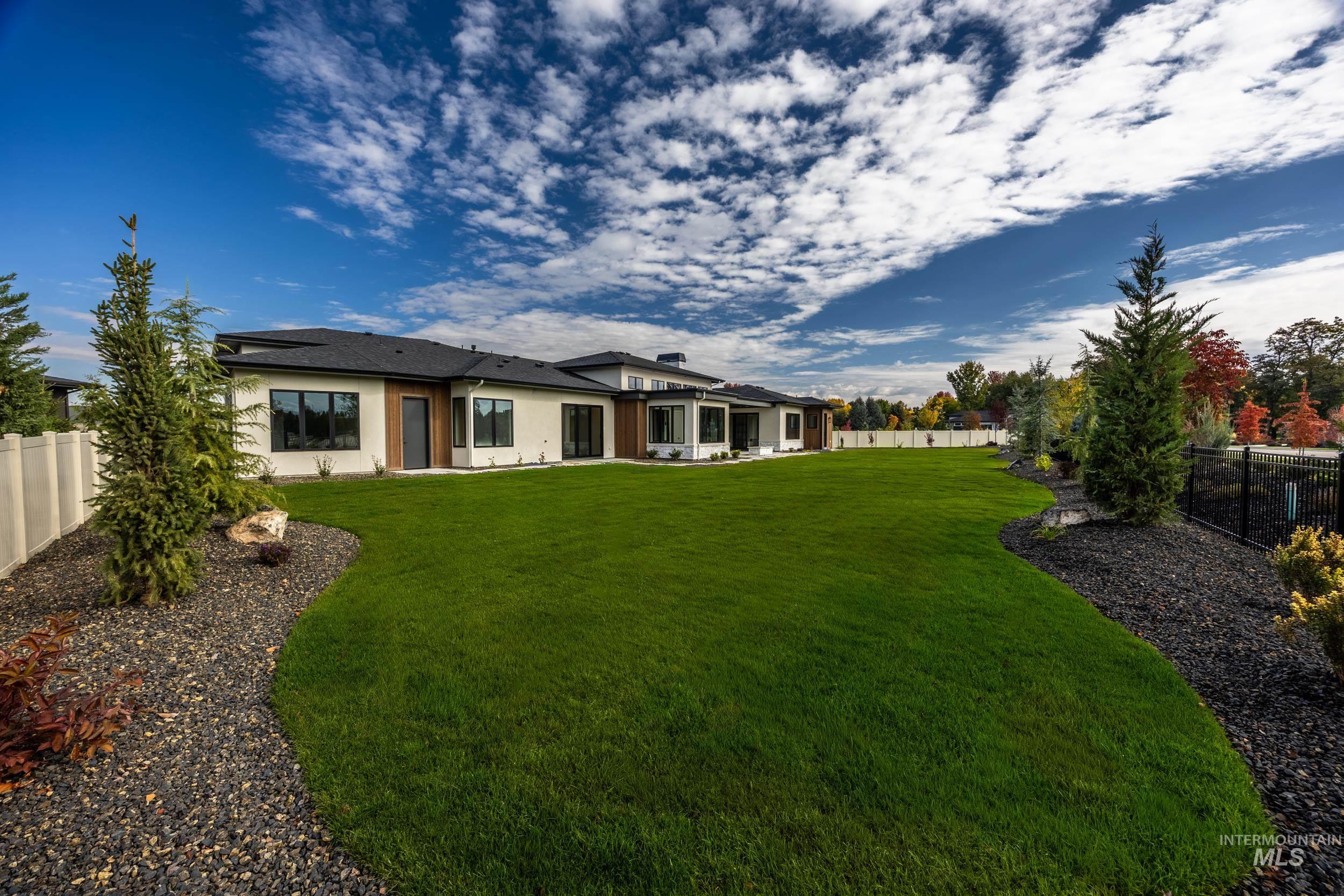 Rear view of house with a fenced backyard, a patio, and stucco siding