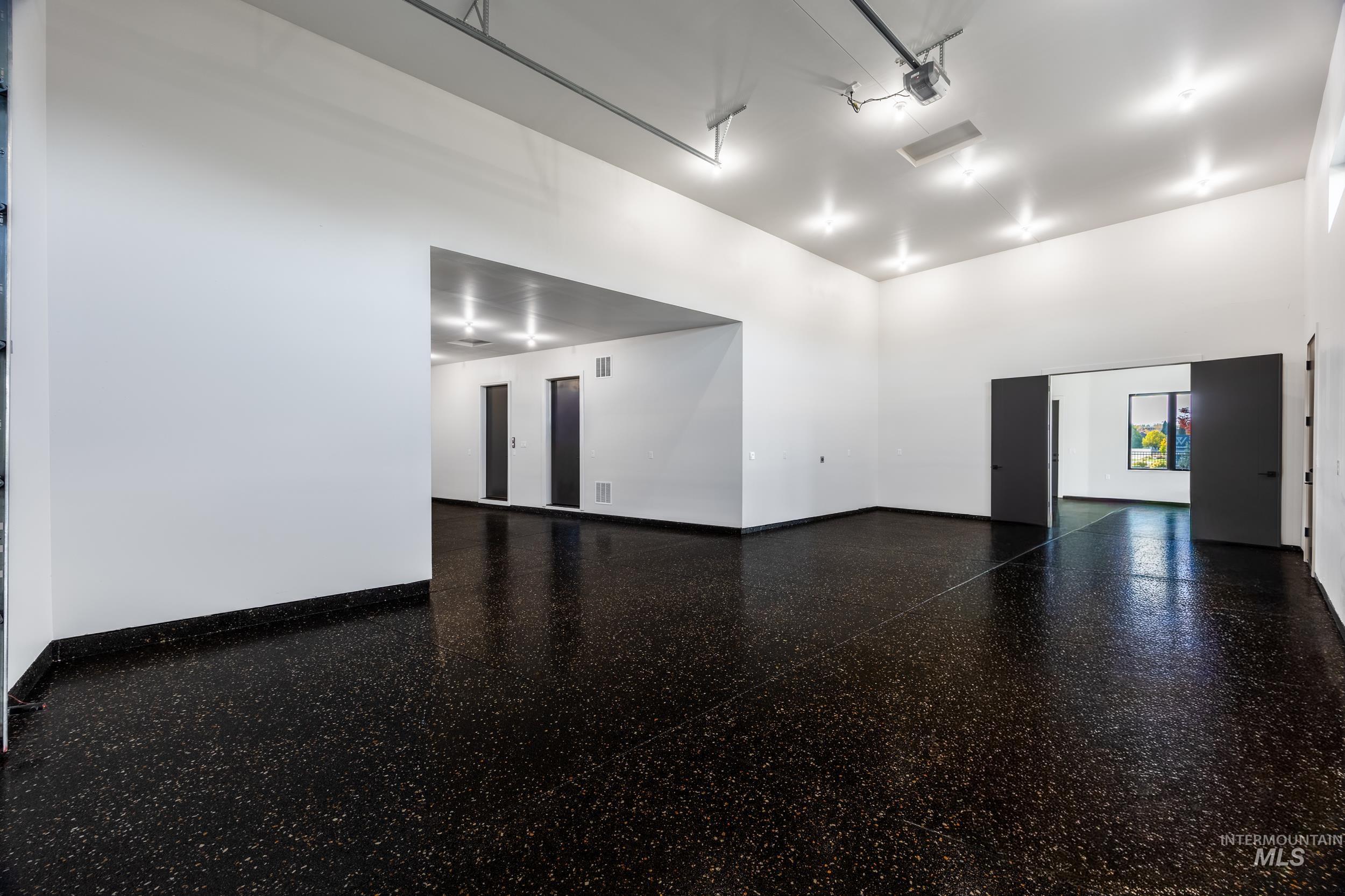 Unfurnished room with baseboards and light speckled floor