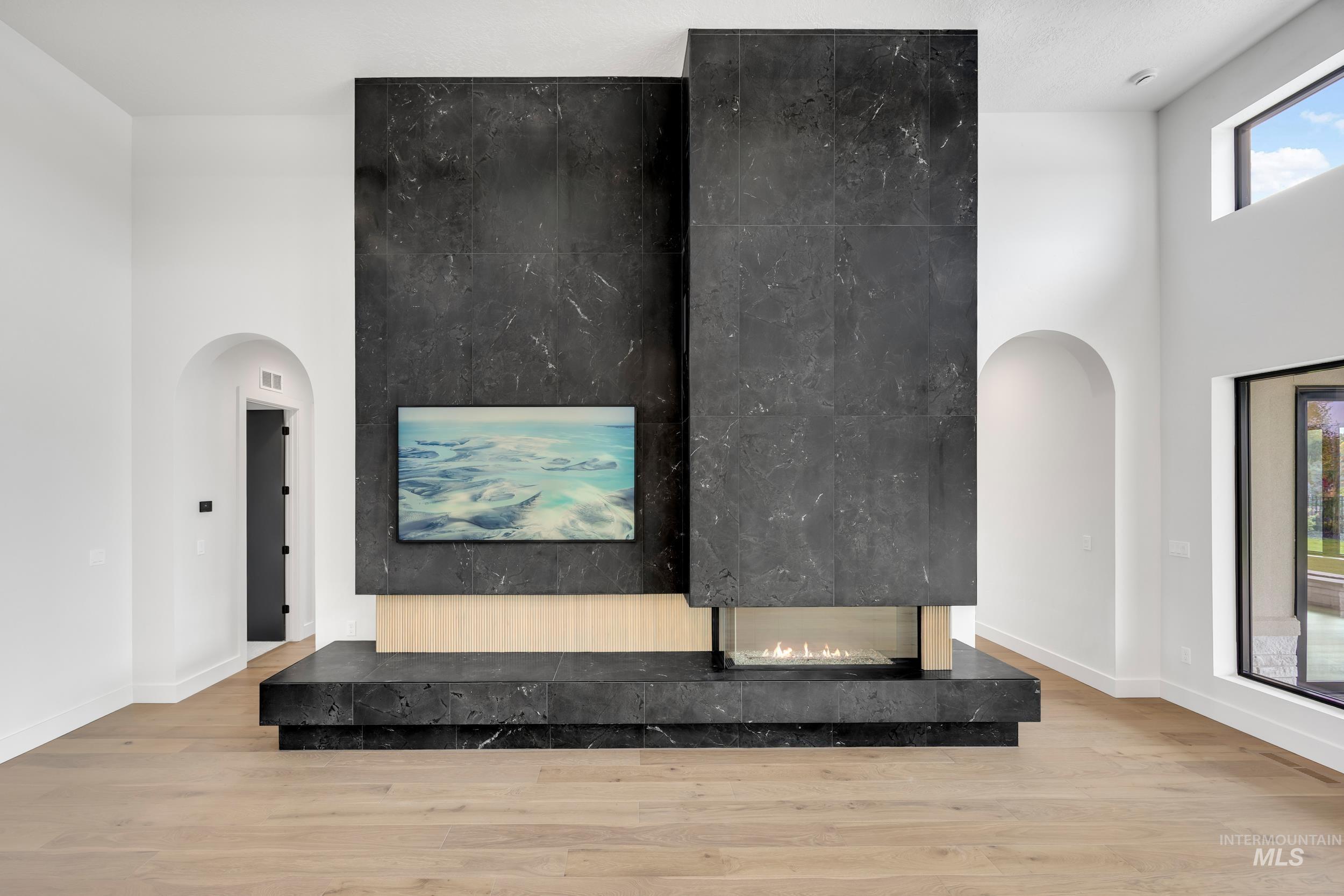 Detailed view of arched walkways, wood finished floors, and a premium fireplace