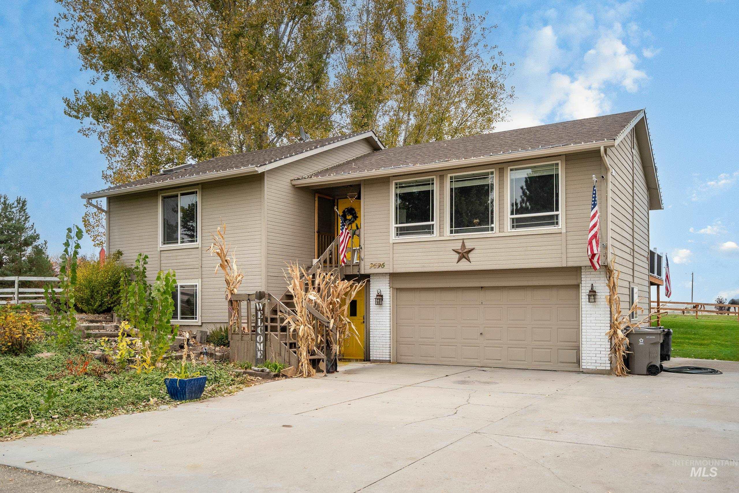 Bi-level home featuring stairway, concrete driveway, an attached garage, and brick siding