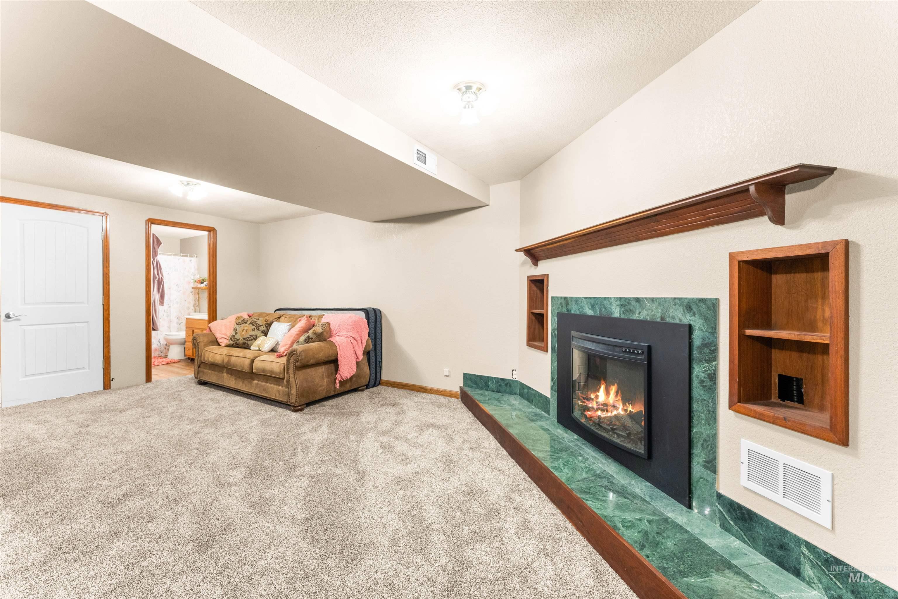 Living area featuring carpet, a high end fireplace, and built in shelves