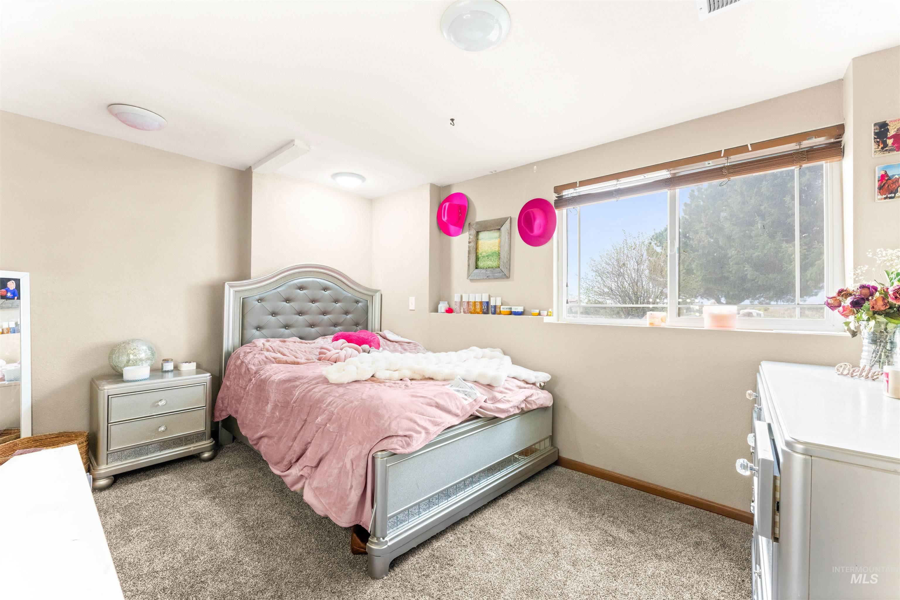 Bedroom with light colored carpet and baseboards
