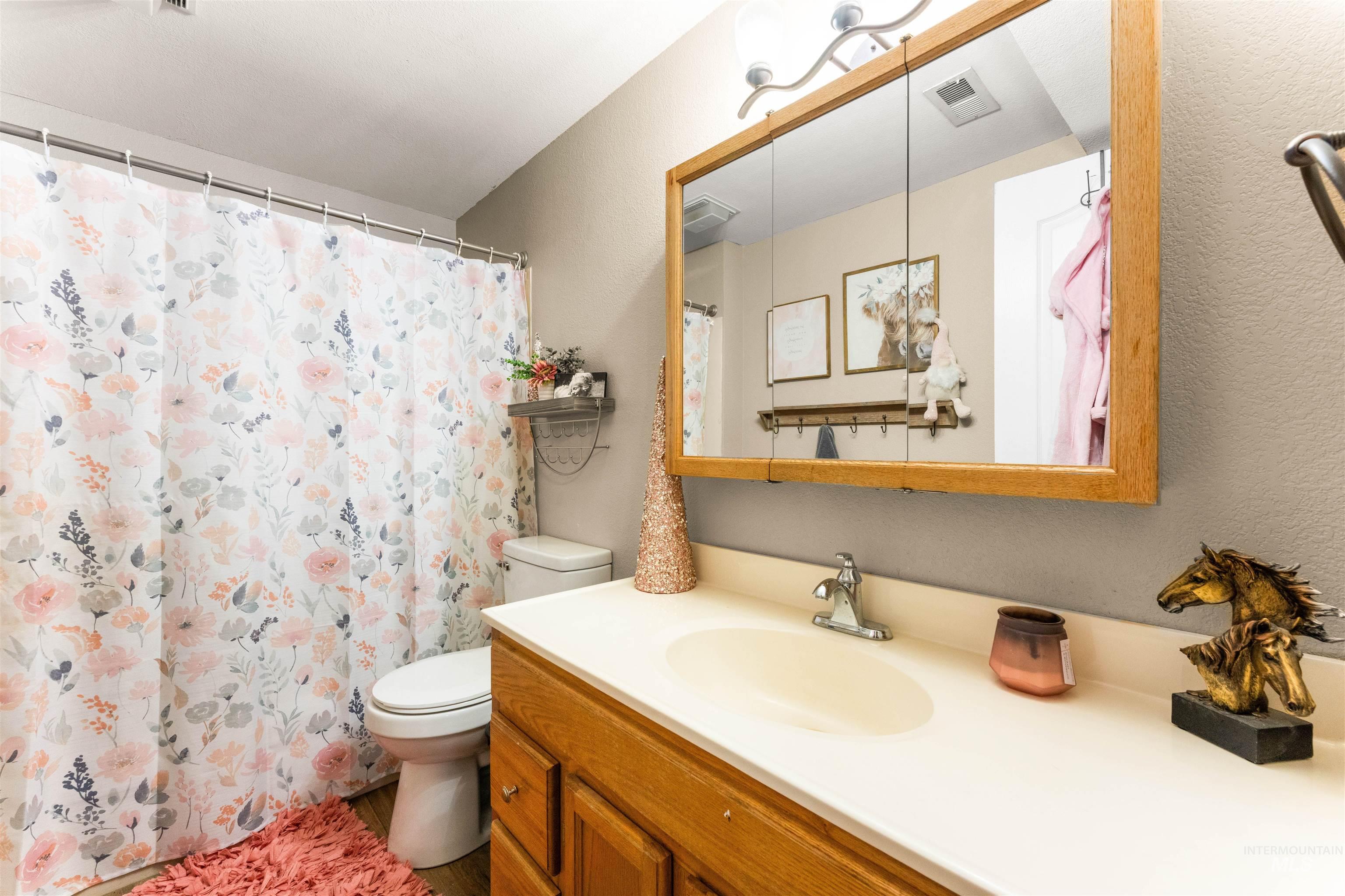 Bathroom featuring a shower with shower curtain and vanity