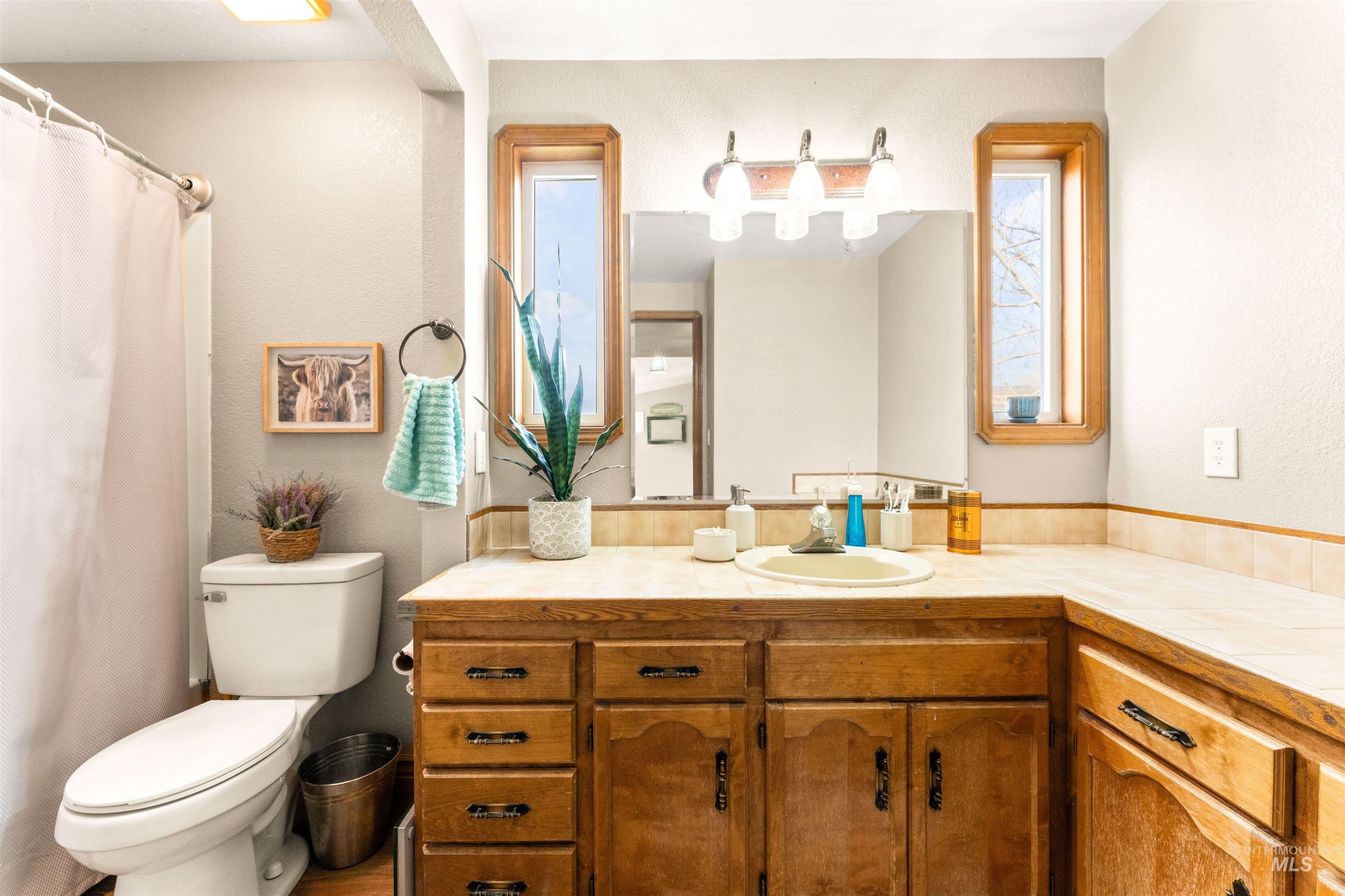Bathroom featuring vanity, curtained shower, and a textured wall
