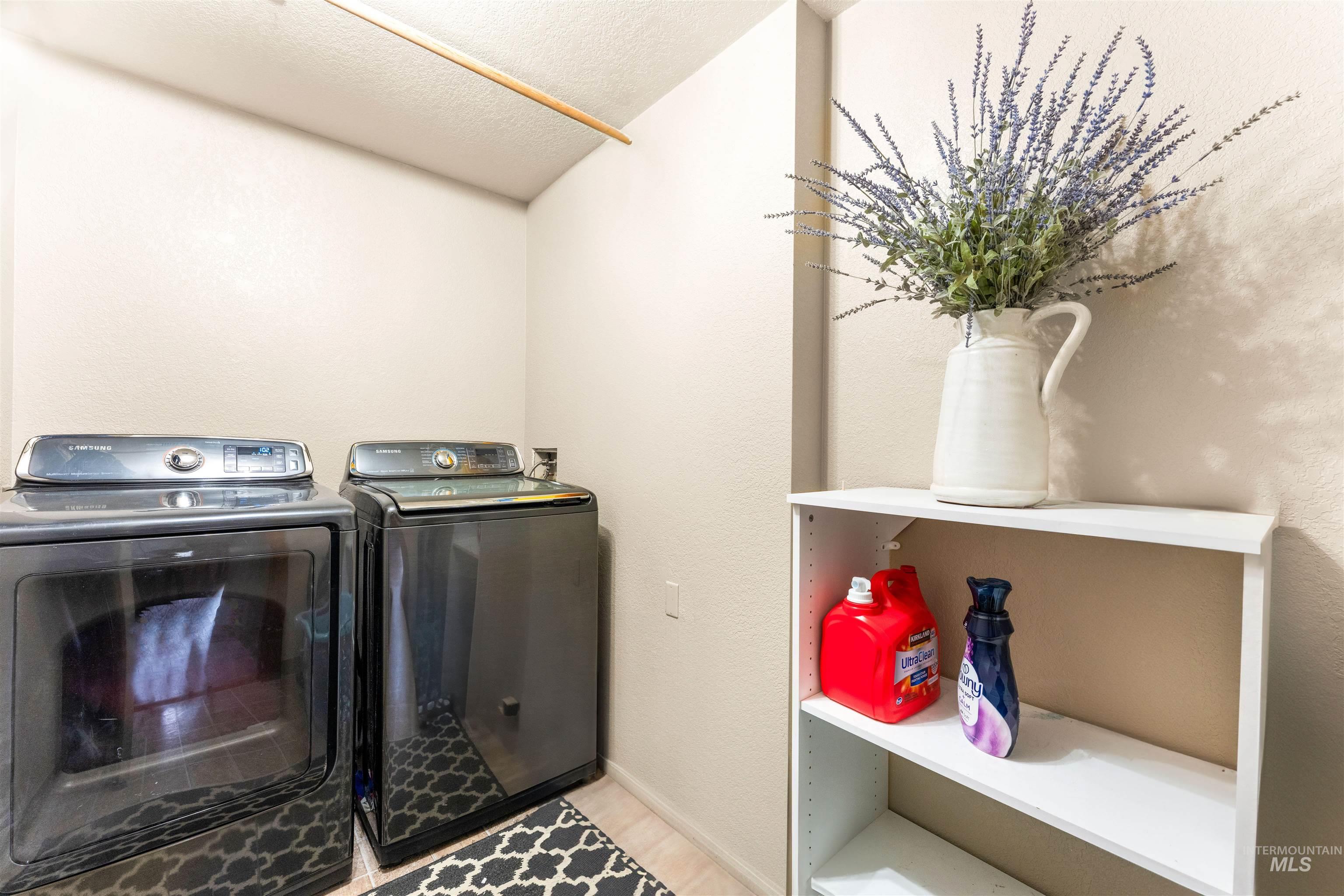 Laundry area with a textured ceiling and independent washer and dryer