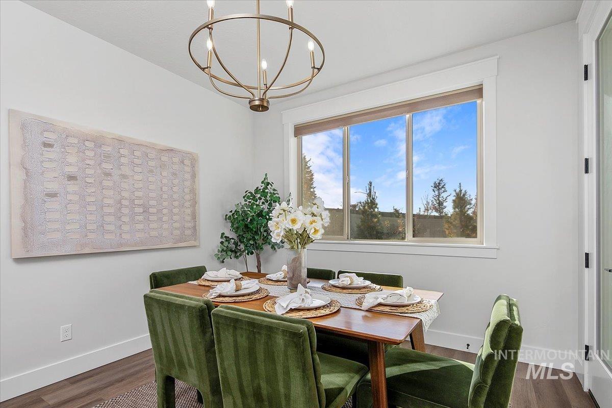 Dining area featuring a chandelier and dark wood-style flooring