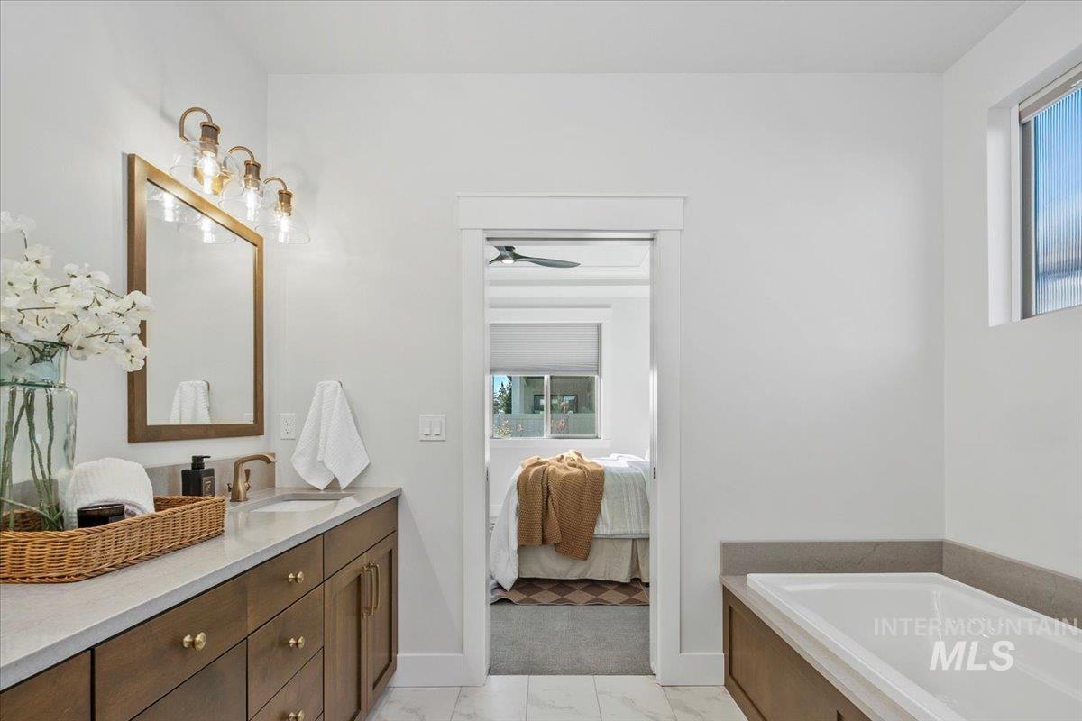 Ensuite bathroom featuring vanity and a bath
