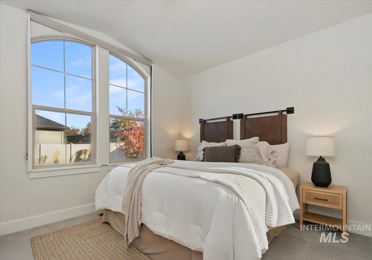 Bedroom featuring lofted ceiling and carpet
