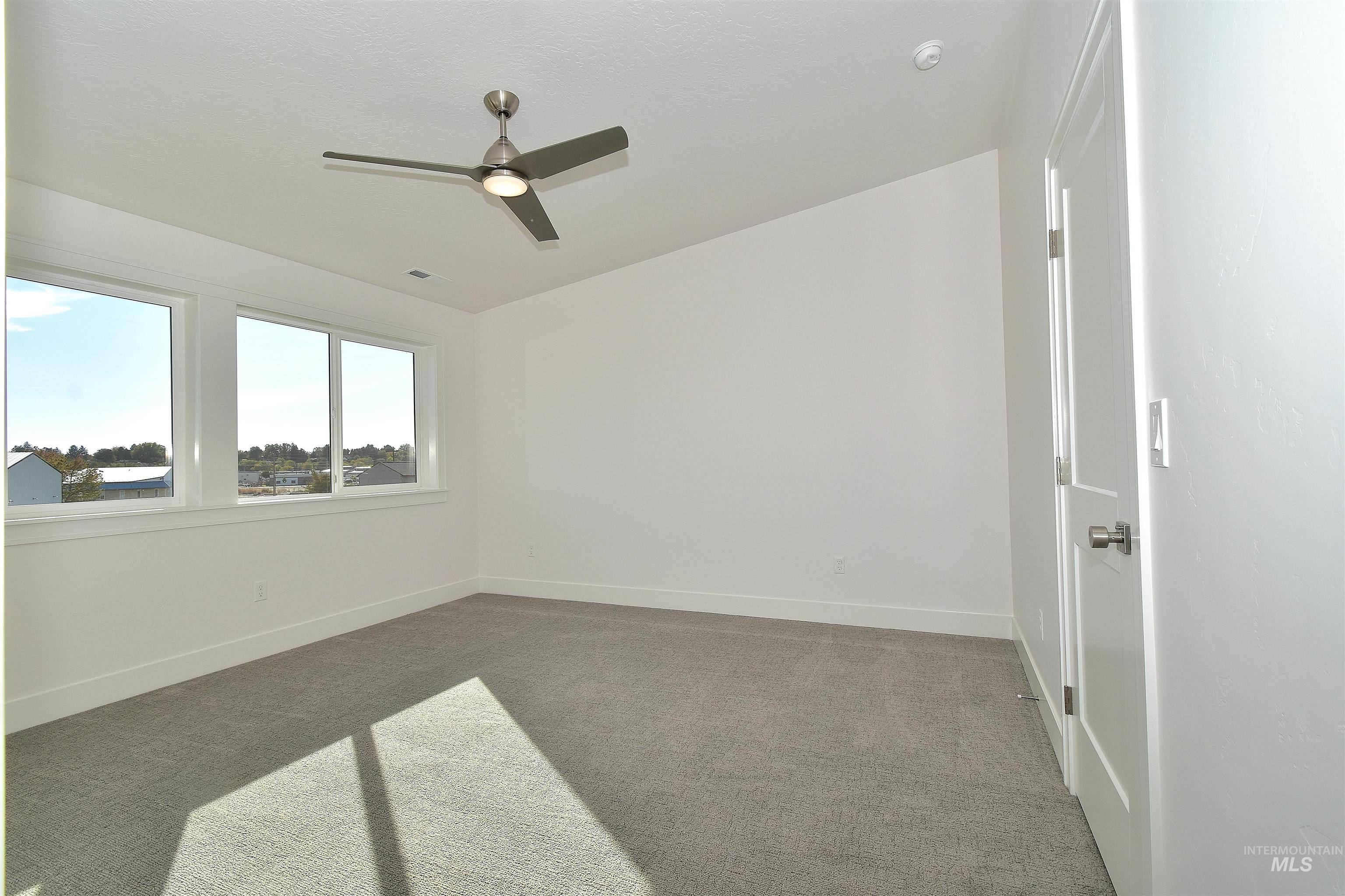 Spare room featuring carpet flooring and a ceiling fan