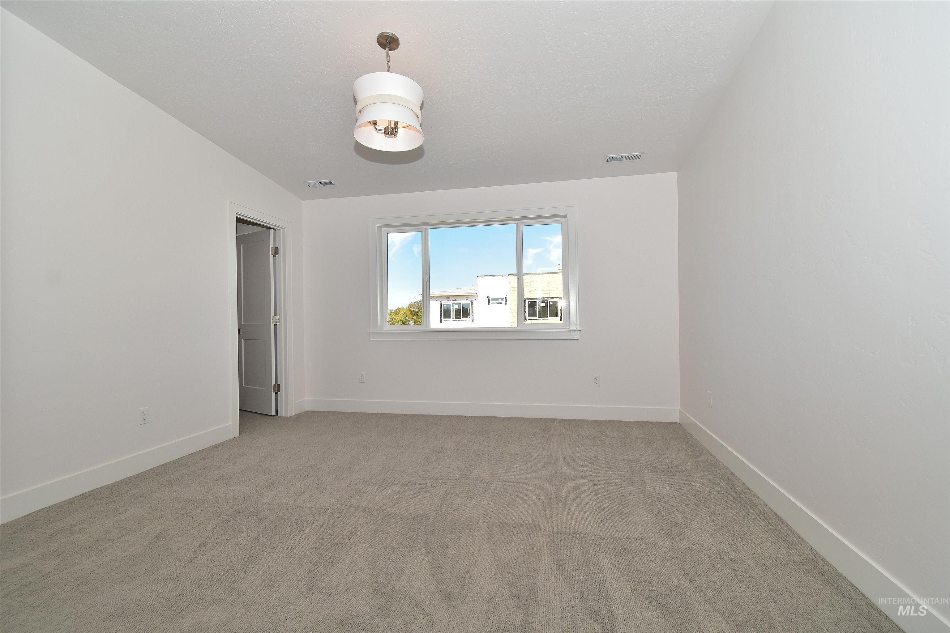 Empty room featuring light colored carpet and baseboards