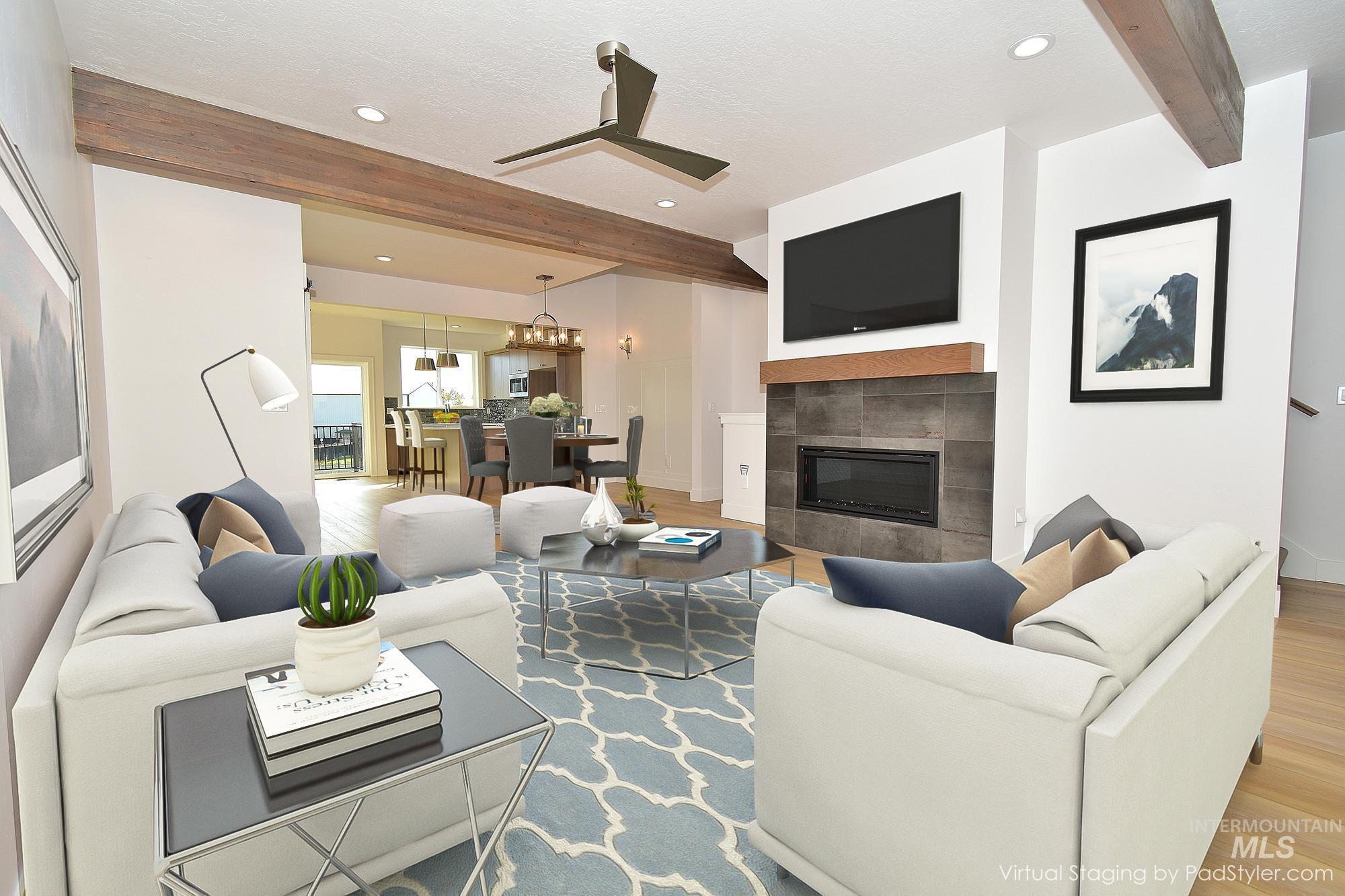 Living area with beam ceiling, a tiled fireplace, light wood finished floors, ceiling fan, and recessed lighting