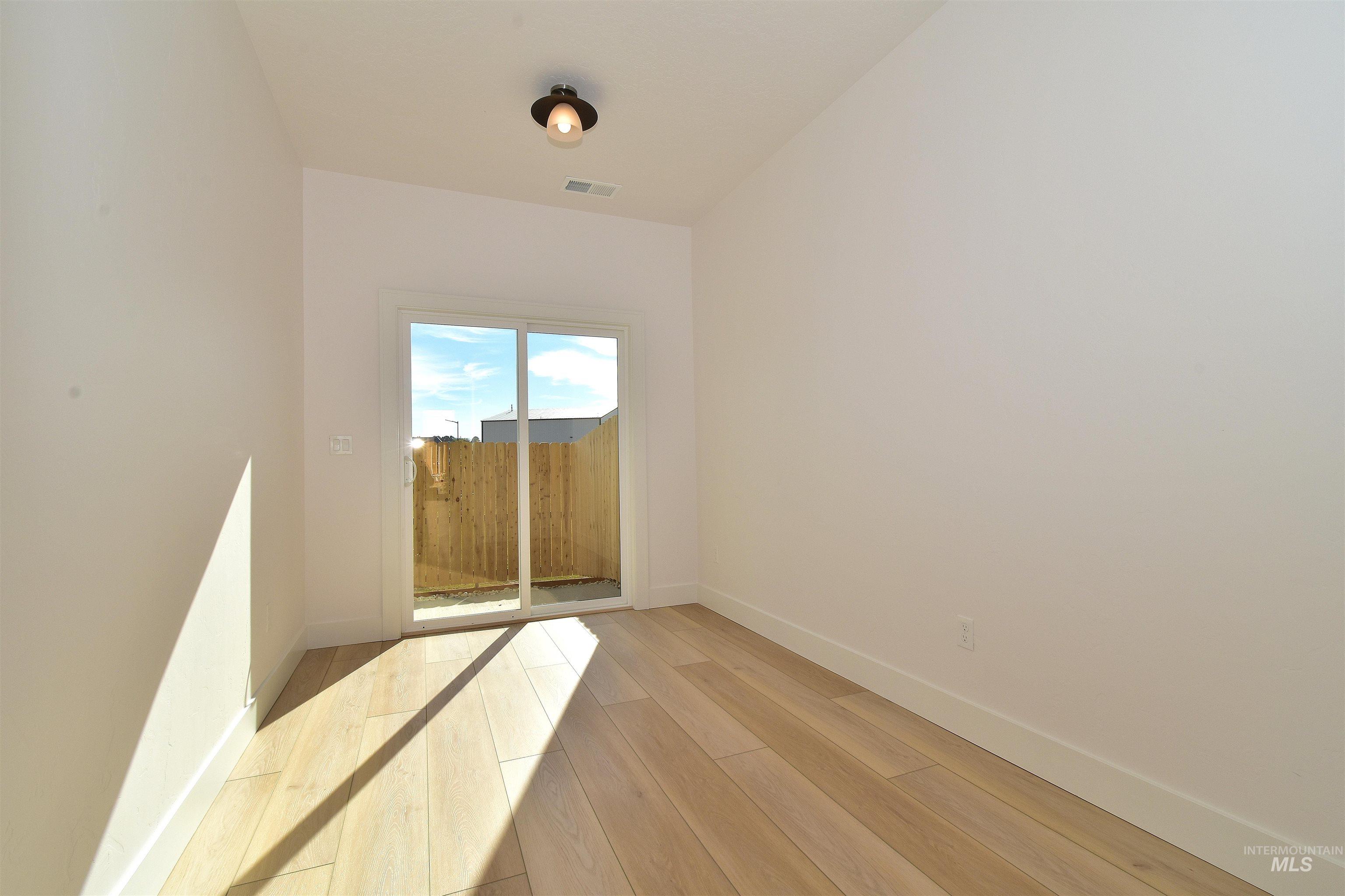 Spare room featuring baseboards and wood finished floors