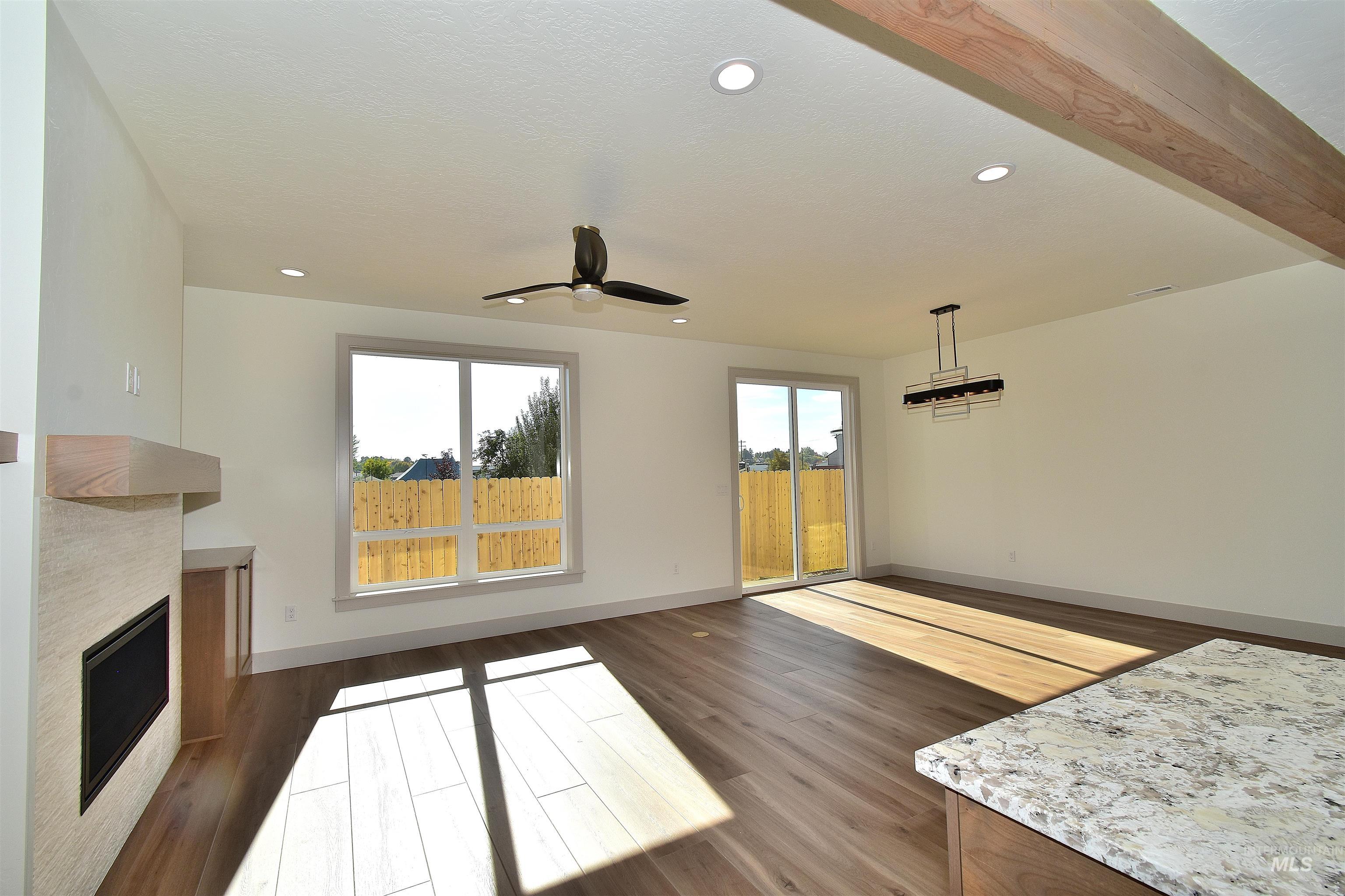 Unfurnished living room with dark wood-style floors, recessed lighting, a ceiling fan, and a fireplace