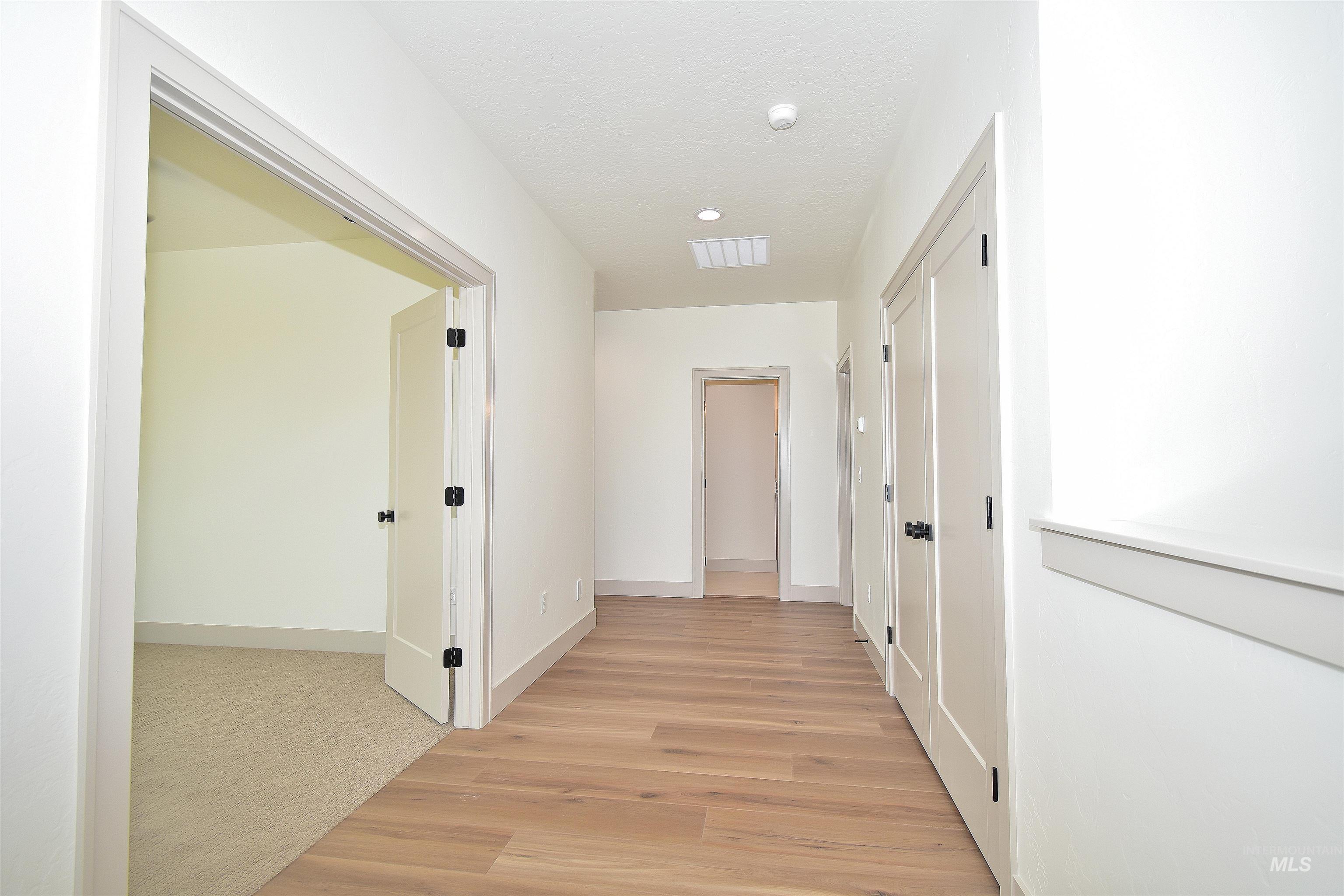 Corridor featuring baseboards and light wood-style floors