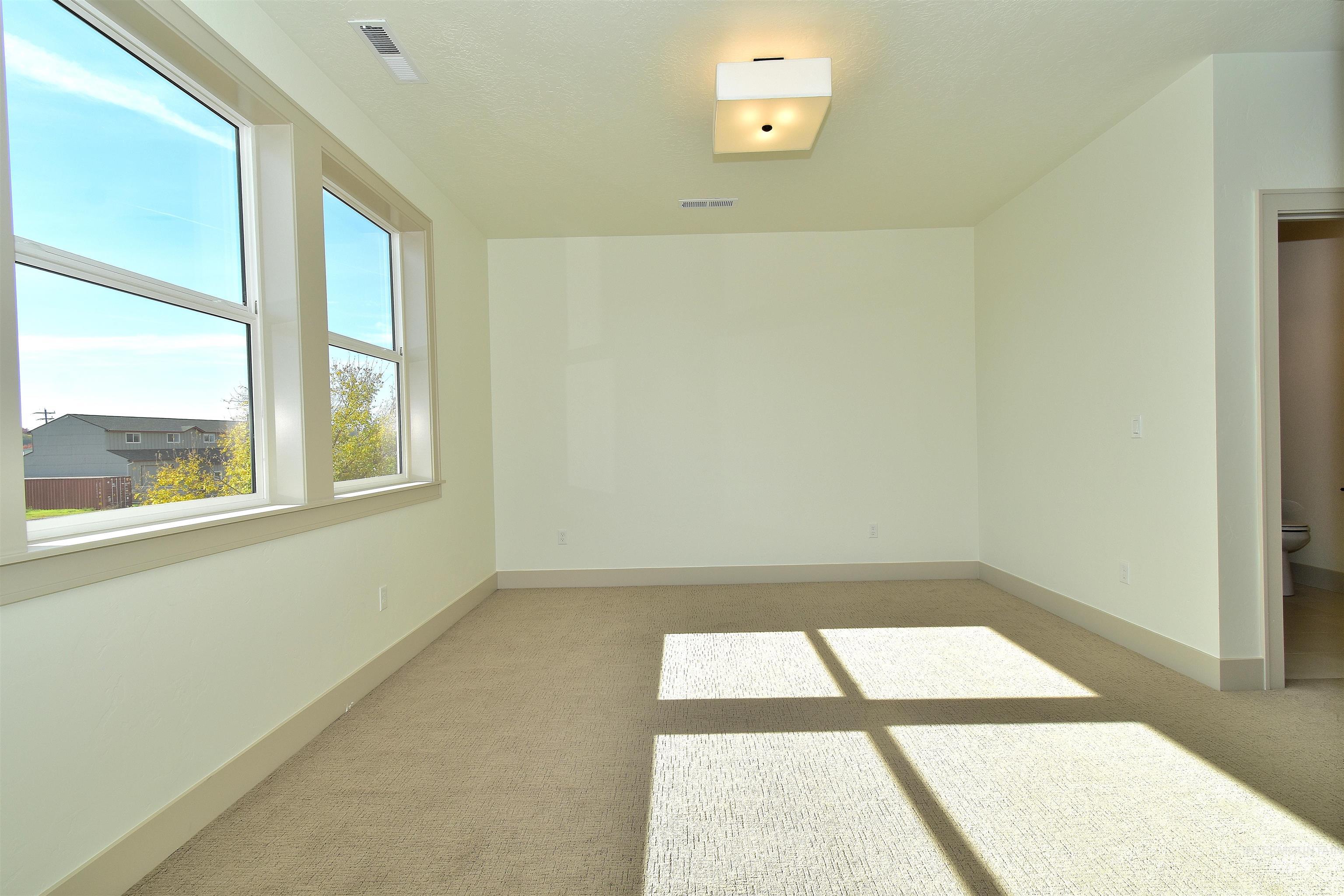 Spare room with light colored carpet and baseboards