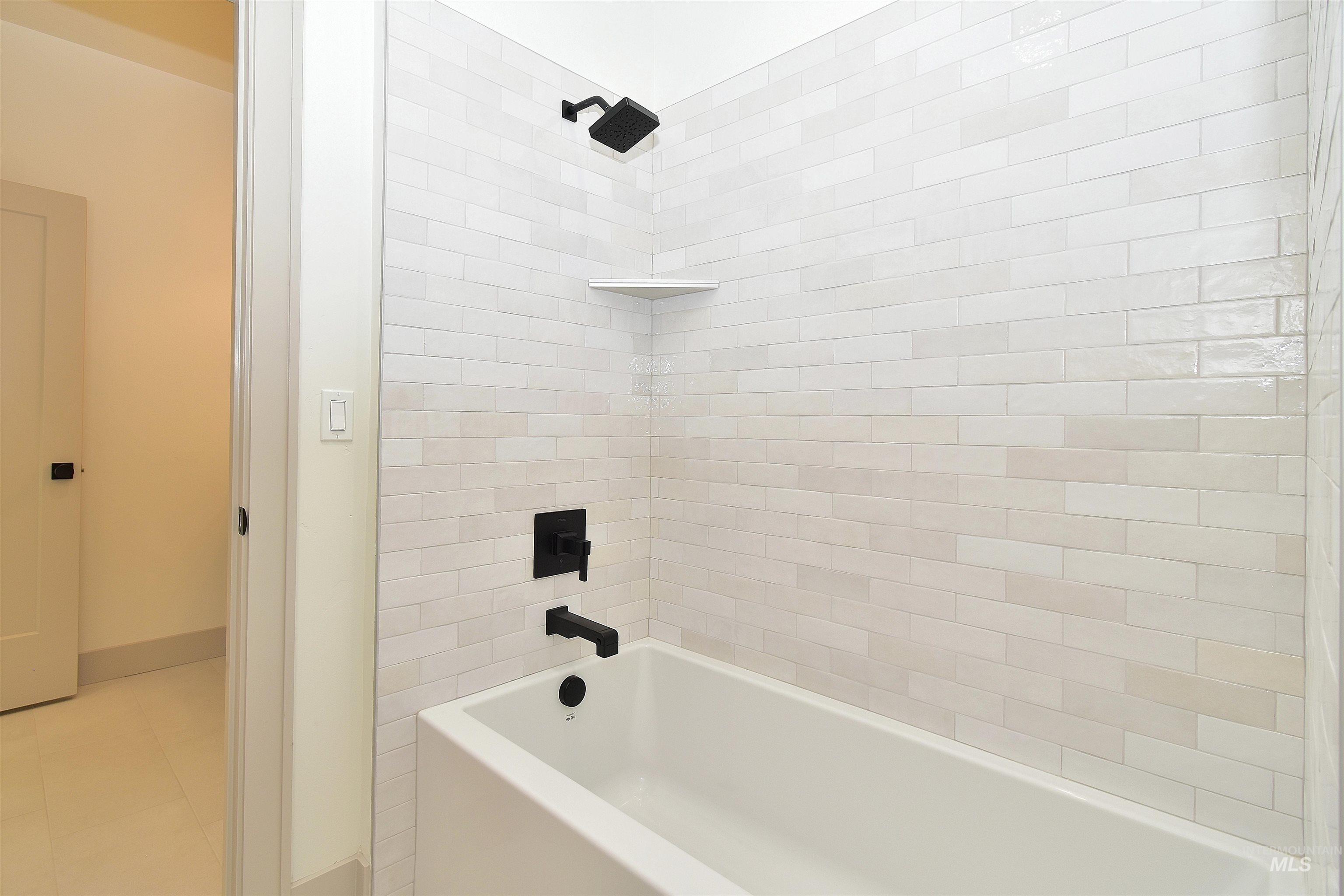 Bathroom featuring tub / shower combination and baseboards