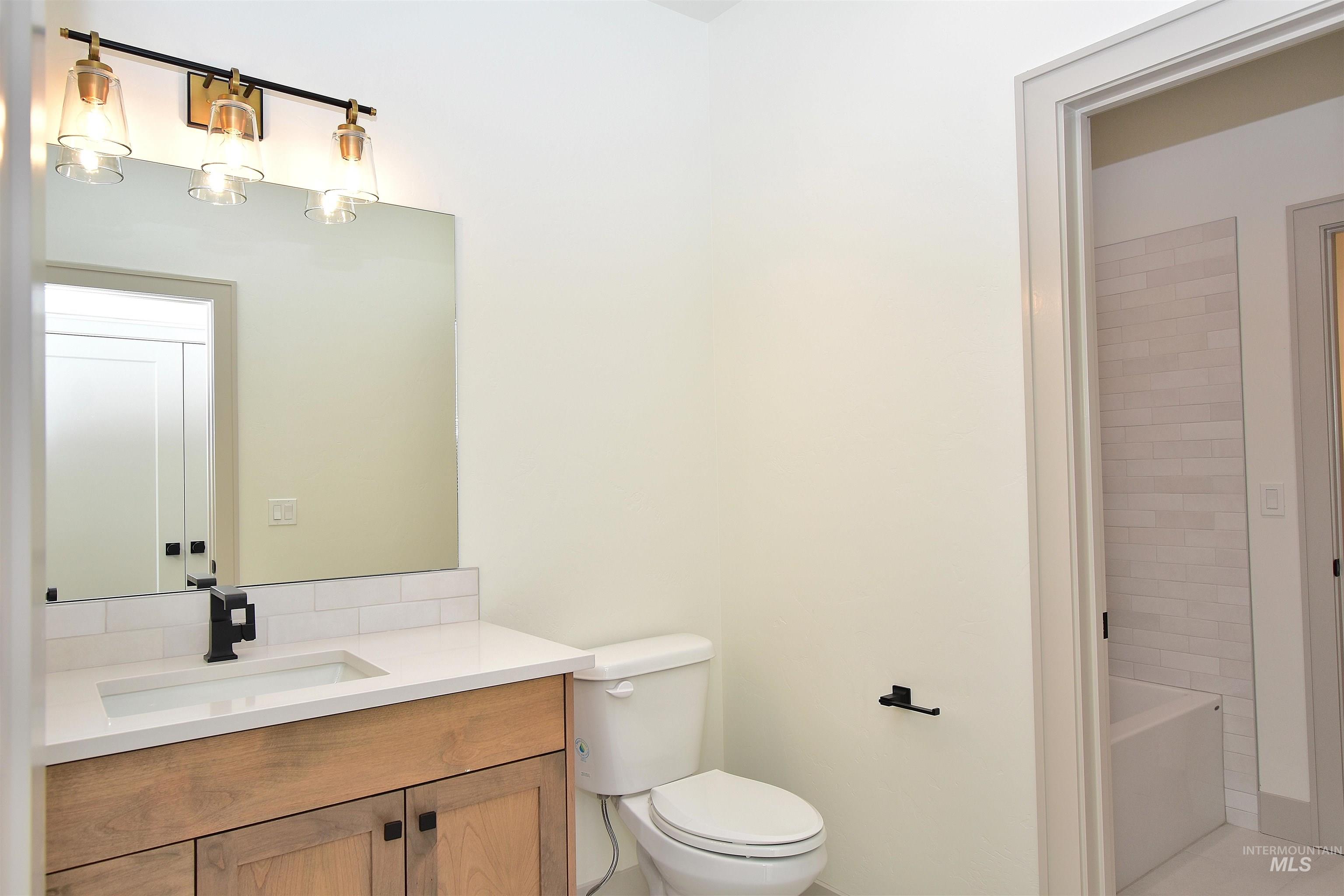 Full bath featuring vanity, a bath, and light tile patterned floors