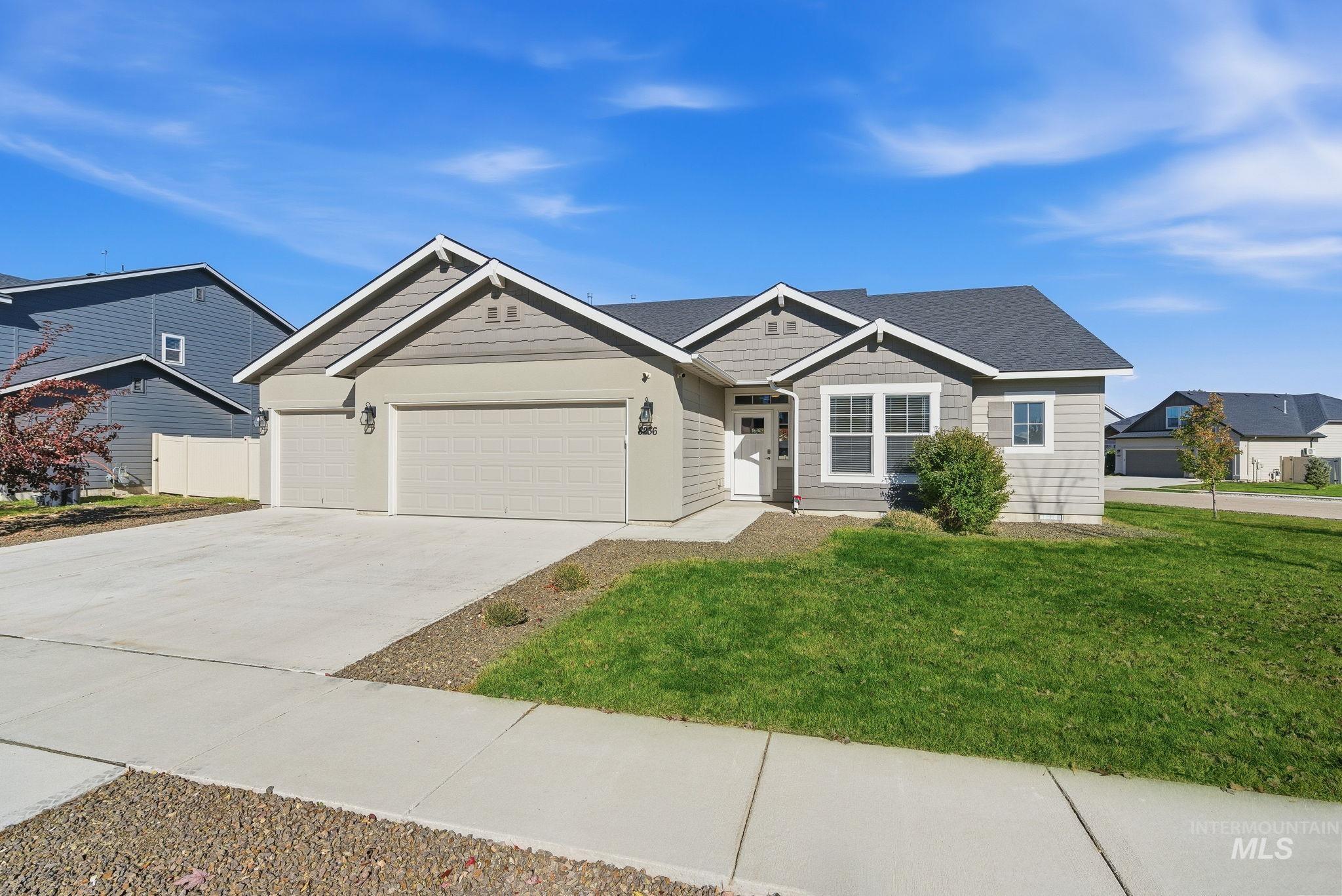 View of front of house with driveway, a front lawn, and an attached garage