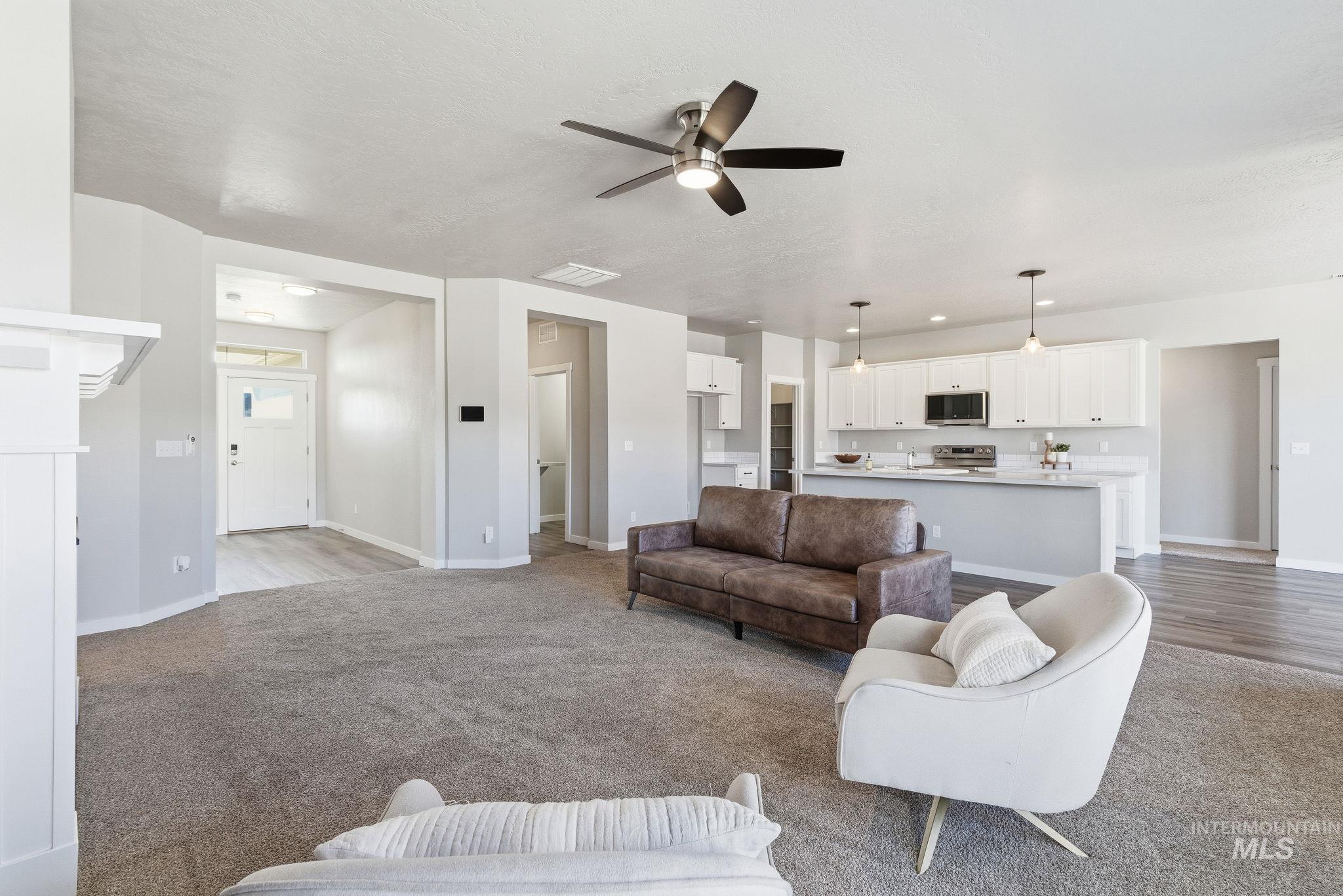Living room featuring a ceiling fan and light colored carpet