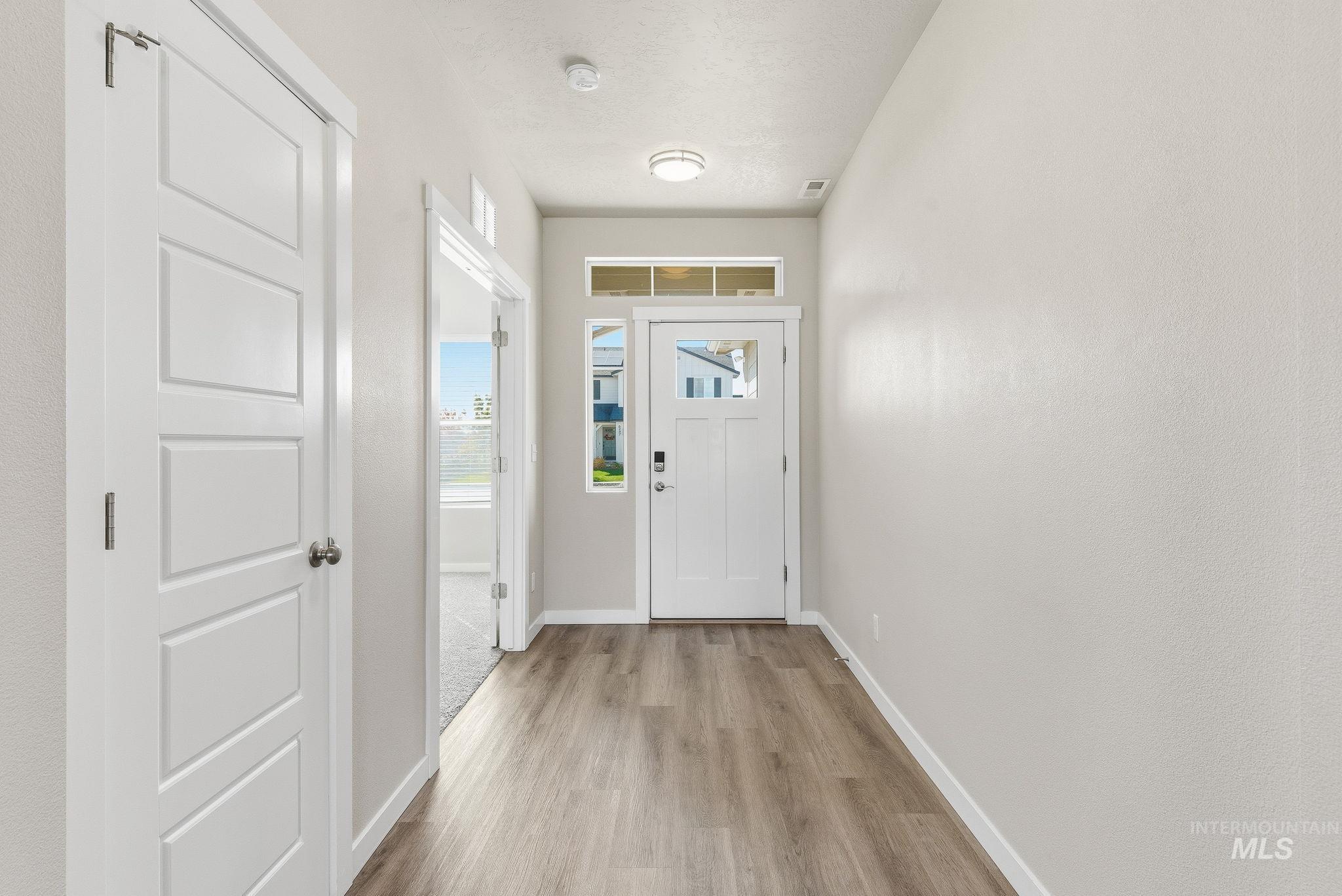 Doorway featuring baseboards and wood finished floors