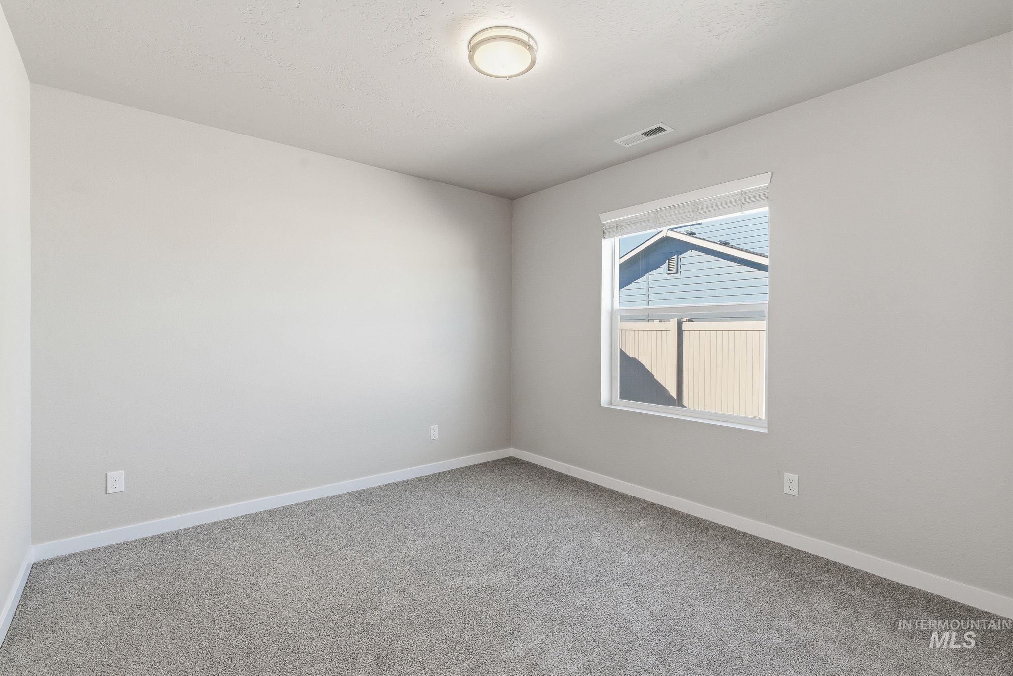 Spare room featuring carpet floors and baseboards