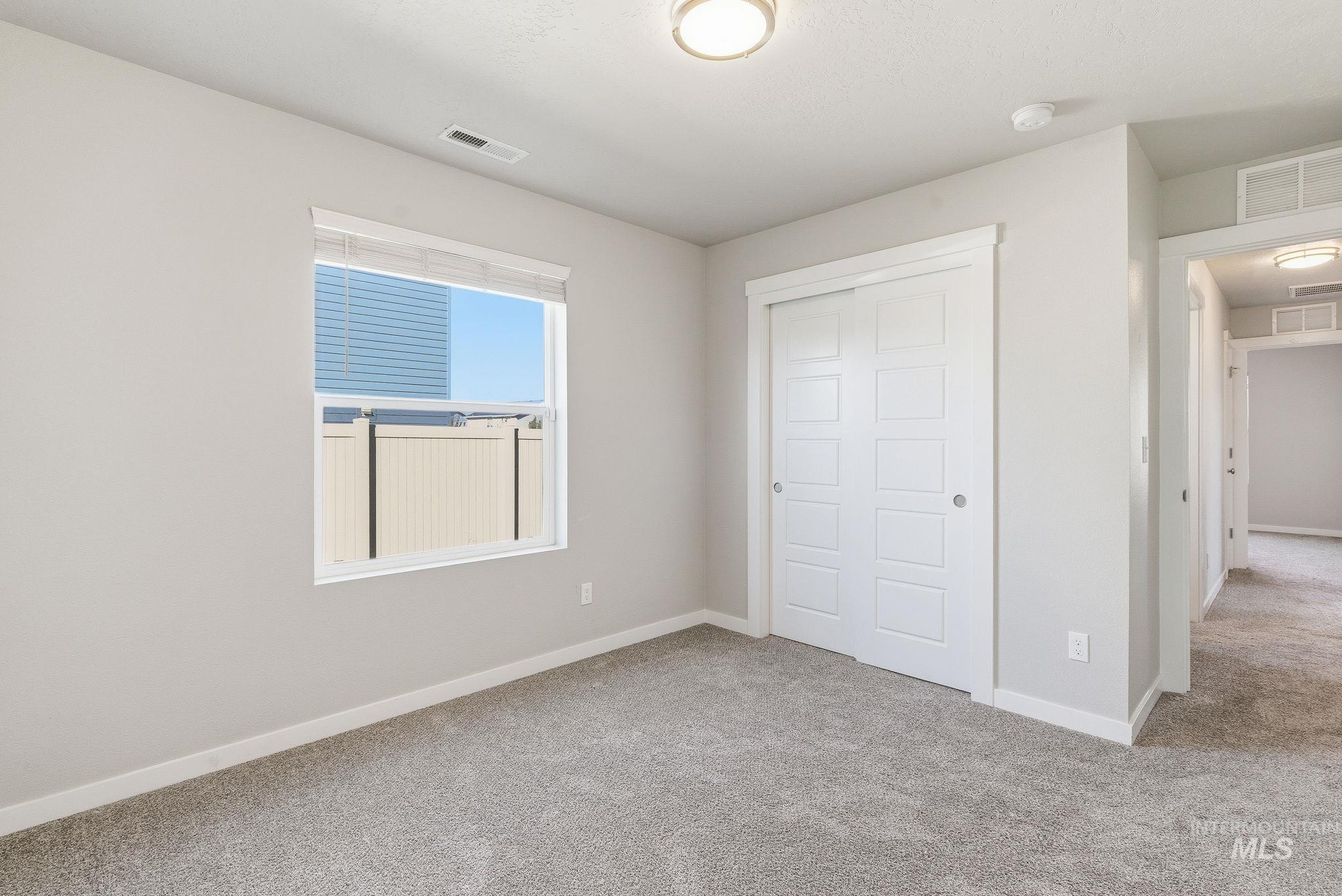 Unfurnished bedroom featuring light carpet and a closet