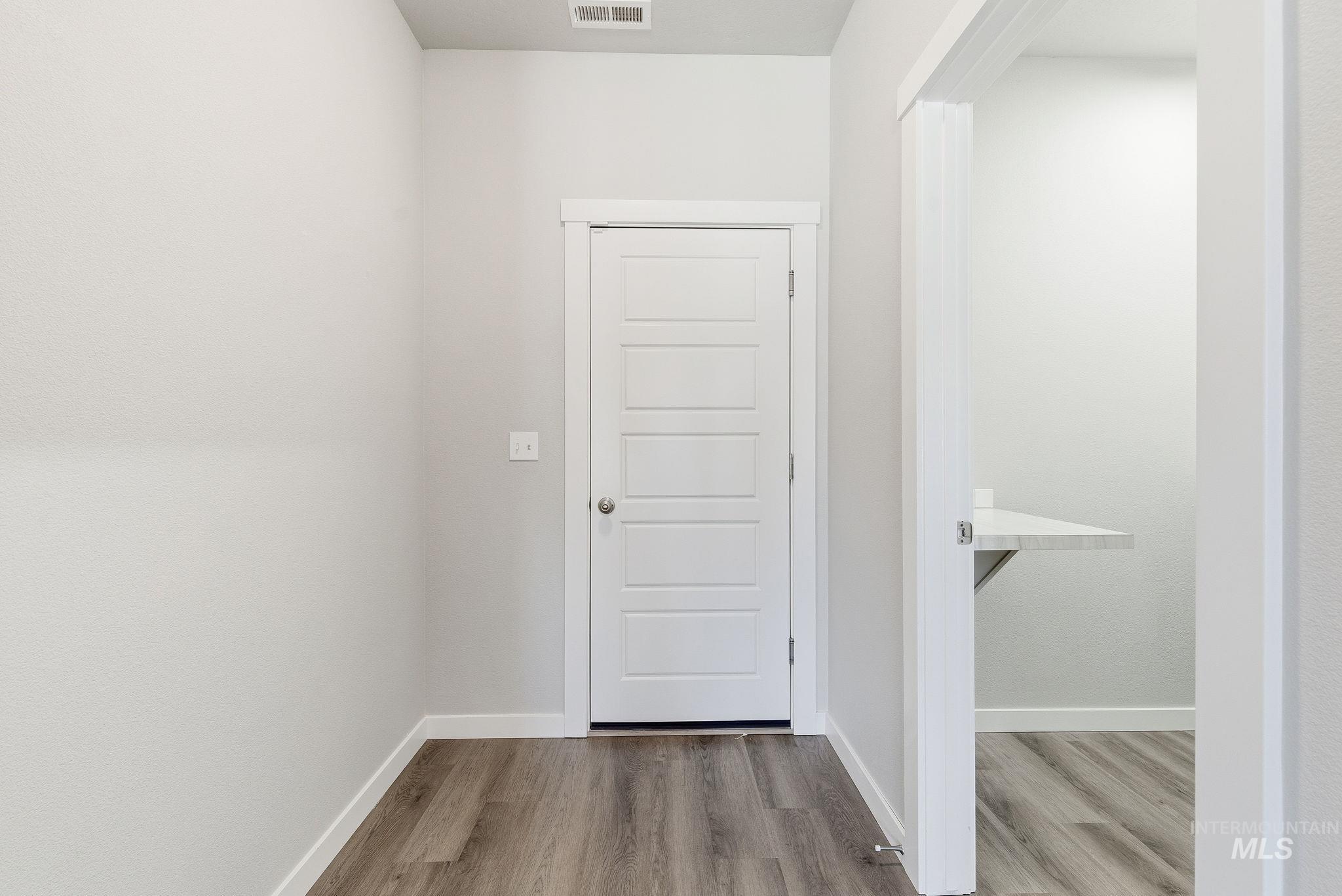 Corridor featuring light wood-style floors and baseboards